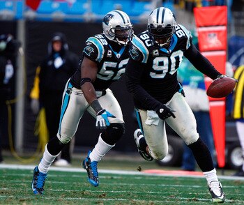 CHARLOTTE, NC - JANUARY 03:  Julius Peppers #90 of the Carolina Panthers runs with the ball alongside teammate Jon Beason #52 after an interception against the New Orleans Saints in the second half of the game at Bank of America Stadium on January 3, 2010