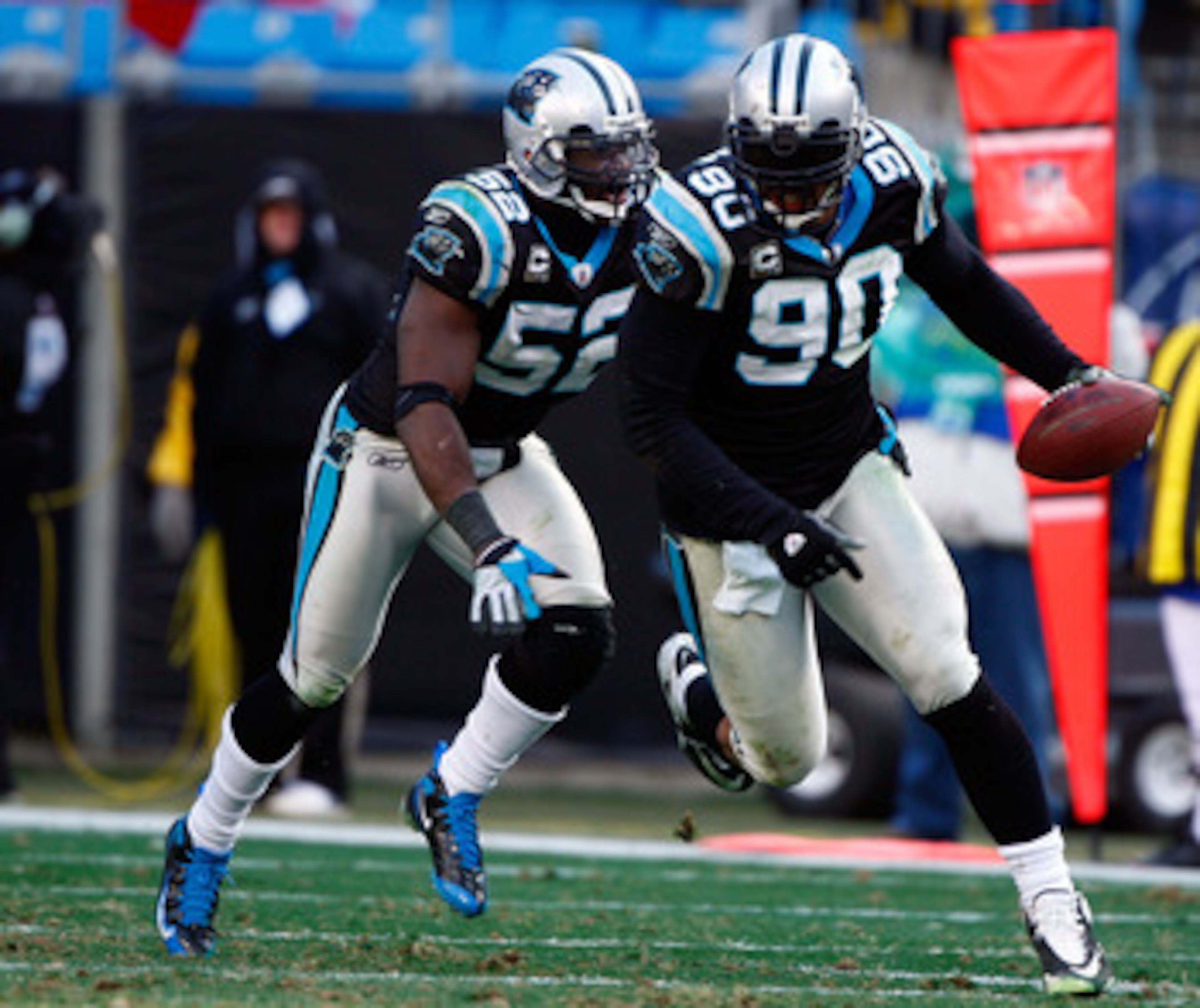CHARLOTTE, NC - JANUARY 03:  Julius Peppers #90 of the Carolina Panthers runs with the ball alongside teammate Jon Beason #52 after an interception against the New Orleans Saints in the second half of the game at Bank of America Stadium on January 3, 2010