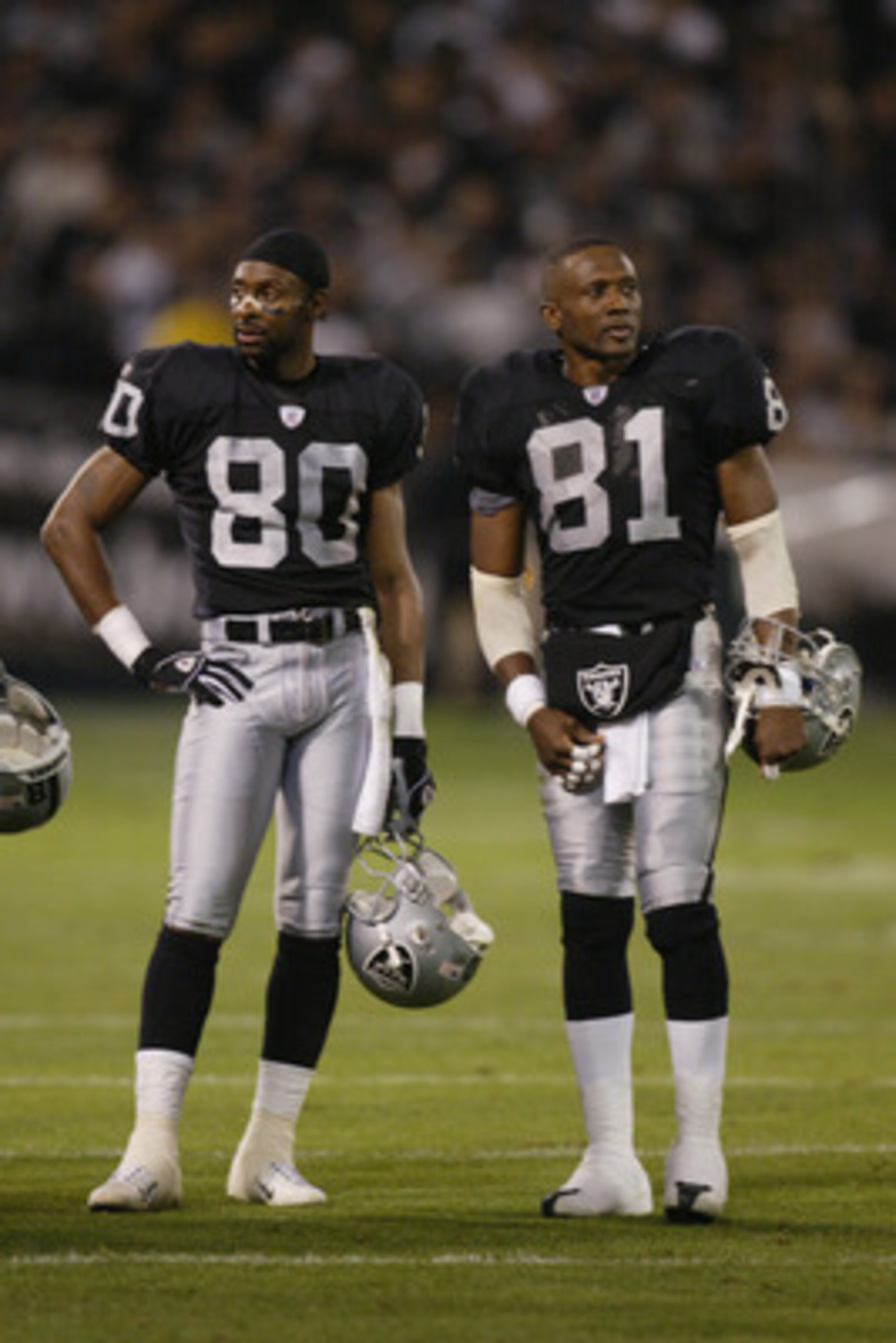 OAKLAND, CA - NOVEMBER 17:  Jerry Rice #80 and Tim Brown #81 of the Oakland Raiders stand on the field during the game against the New England Patriots on November 17, 2002 at Network Associates Coliseum in Oakland, California. The Raiders defeated the Pa