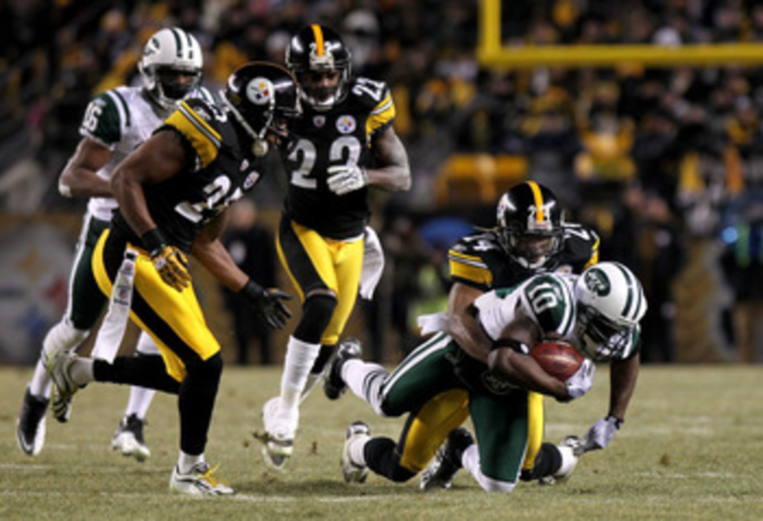 PITTSBURGH, PA - JANUARY 23:  Santonio Holmes #10 of the New York Jets is tackled by Ike Taylor #24 of the Pittsburgh Steelers during the 2011 AFC Championship game at Heinz Field on January 23, 2011 in Pittsburgh, Pennsylvania. The Steelers won 24-19. (P