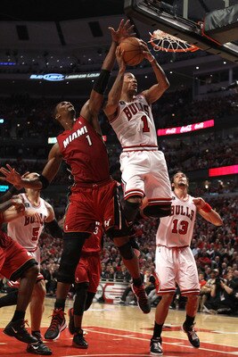 CHICAGO, IL - MAY 18:  Derrick Rose #1 of the Chicago Bulls drives for a shot attempt against Chris Bosh #1 of the Miami Heat in Game Two of the Eastern Conference Finals during the 2011 NBA Playoffs on May 18, 2011 at the United Center in Chicago, Illino