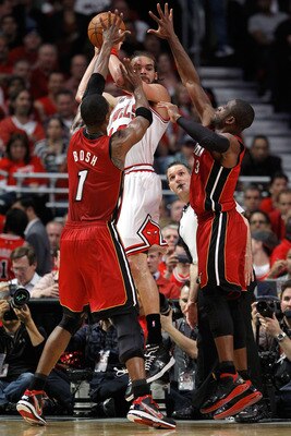CHICAGO, IL - MAY 18:  Joakim Noah #13 of the Chicago Bulls looks to pass as he is defended by Chris Bosh #1 and Dwyane Wade #3 of the Miami Heat in Game Two of the Eastern Conference Finals during the 2011 NBA Playoffs on May 18, 2011 at the United Cente