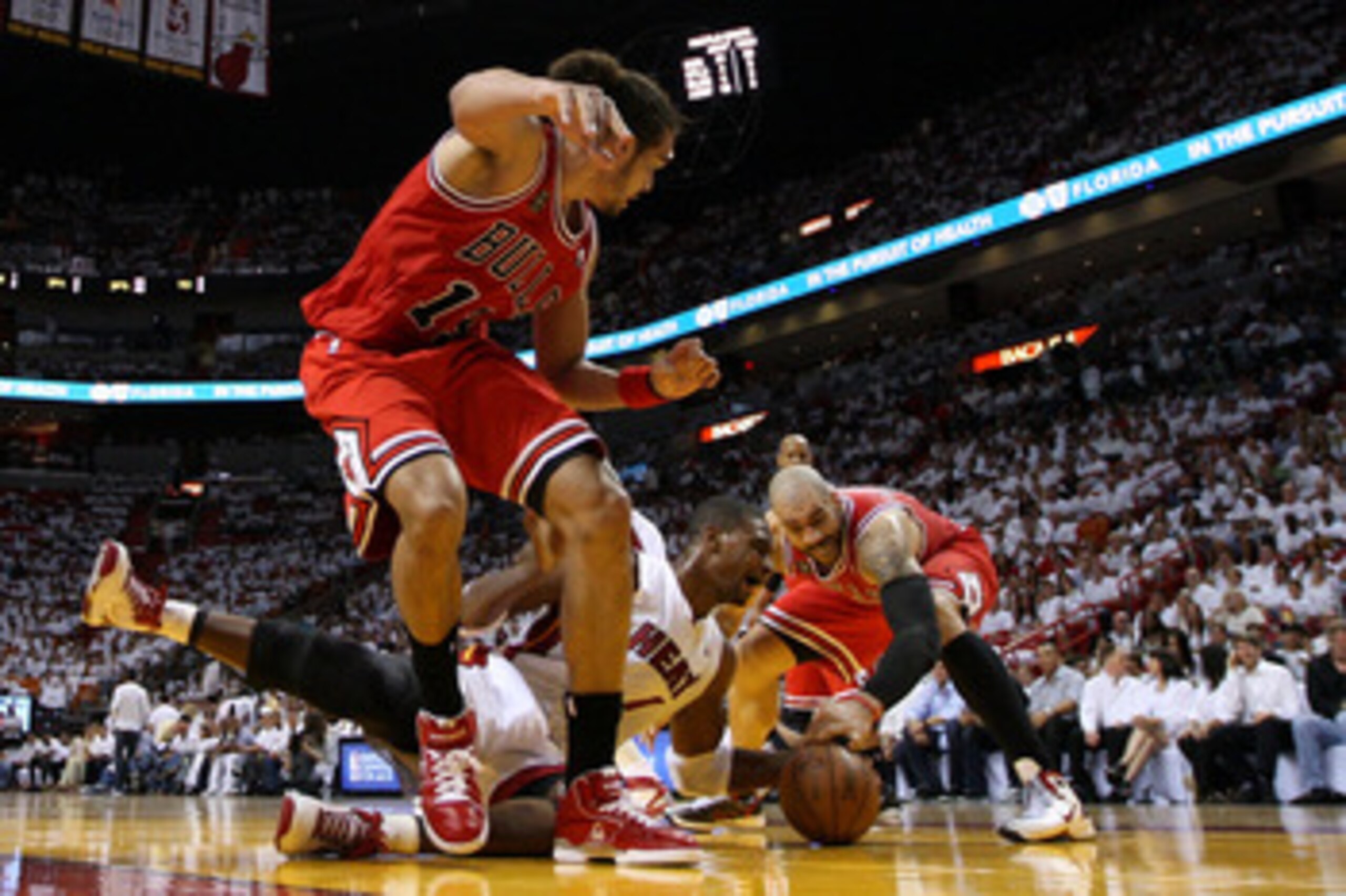MIAMI, FL - MAY 22: Chris Bosh #1 of the Miami Heat attempts to control a loose ball against Carlos Boozer #5 and Joakim Noah #13 of the Chicago Bulls in Game Three of the Eastern Conference Finals during the 2011 NBA Playoffs on May 22, 2011 at American MIAMI, FL - MAY 22: Chris Bosh #1 of the Miami Heat attempts to control a loose ball against Carlos Boozer #5 and Joakim Noah #13 of the Chicago Bulls in Game Three of the Eastern Conference Finals during the 2011 NBA Playoffs on May 22, 2011 at American