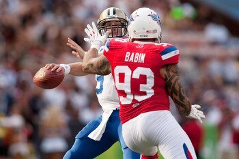 HONOLULU - JANUARY 30:  Drew Brees, #9 of the New Orleans Saints, looks for an open receiver while Jason Babin, #93 of the Tennessee Titans, defends during the 2011 NFL Pro Bowl at Aloha Stadium on January 30, 2011 in Honolulu, Hawaii. NFC won 55-41 over 