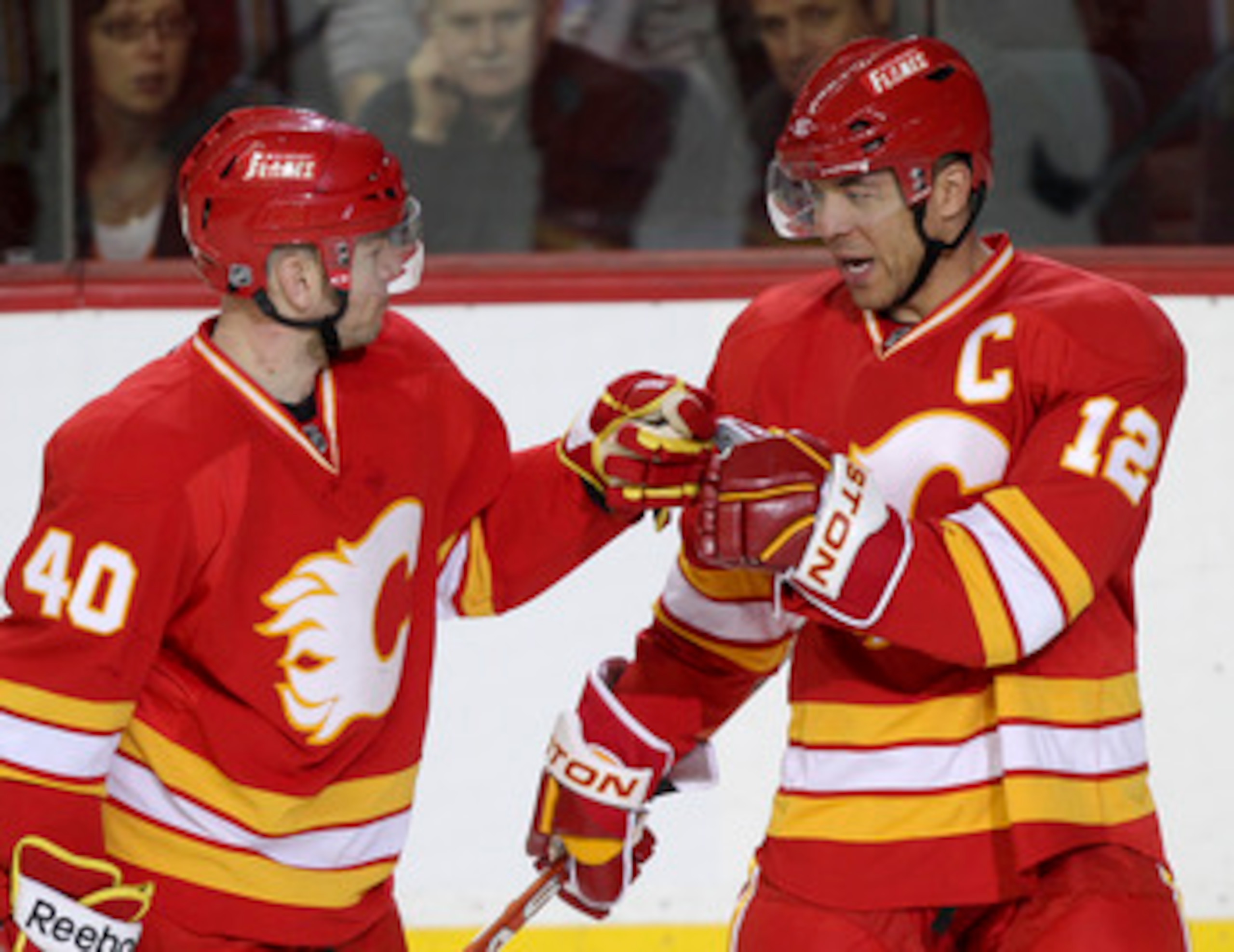 CALGARY, CANADA - APRIL 6:Jarome Iginla #12 of the Calgary Flames is congratulated by teammate Alex Tanguay #40 on his hat trick goal against  the Edmonton Oilers in third period NHL action on April 6, 2011 at the Scotiabank Saddledome in Calgary, Alberta