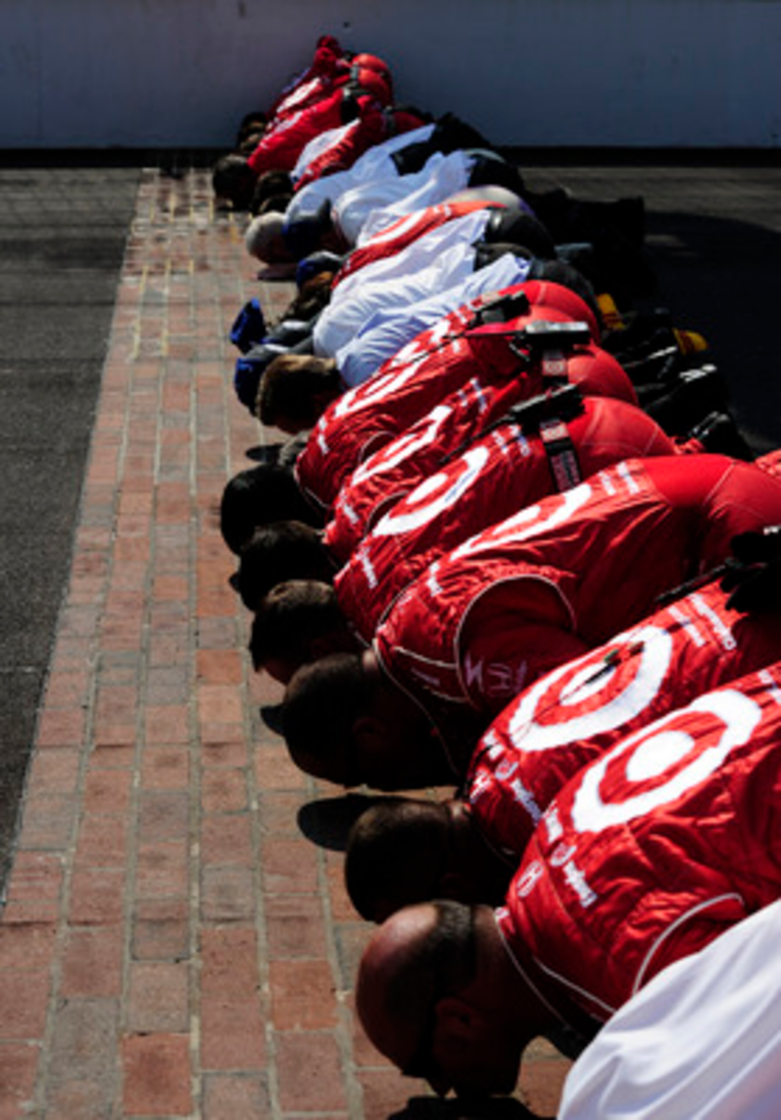 INDIANAPOLIS - MAY 30:  Dario Franchitti of Scotland, driver of the #10 Target Chip Ganassi Racing Dallara Honda, celebrates with his team as they kiss the bricks after winning the IZOD IndyCar Series 94th running of the Indianapolis 500 at the Indianapol