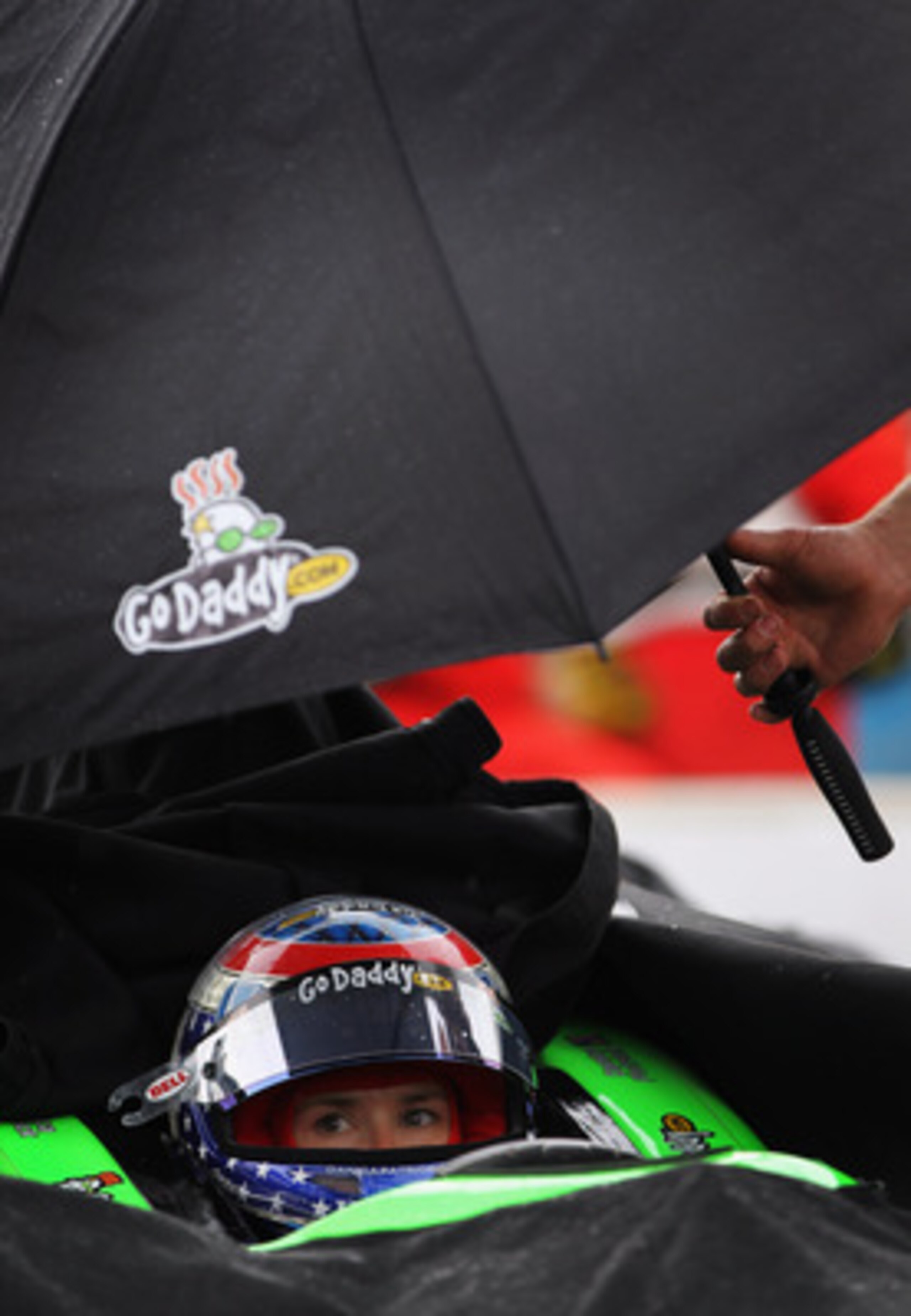 INDIANAPOLIS, IN - MAY 22:  Danica Patrick, driver of the #7 Team GoDaddy Dallara Honda, waits in the rain while her car is covered as the next to qualify when the session was postponed due to rain during qualifying for the Indianapolis 500 on May 22, 201