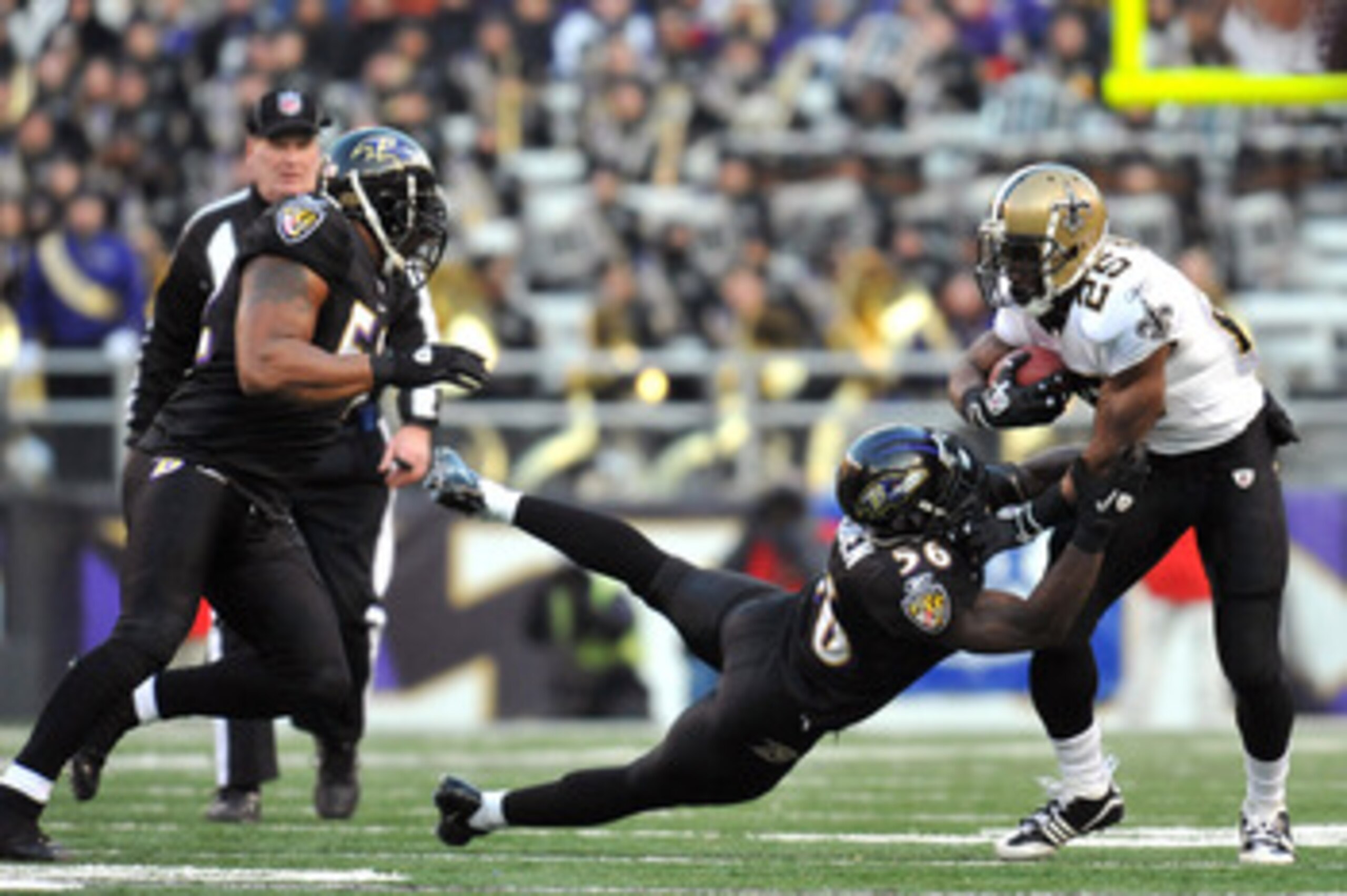 BALTIMORE, MD - DECEMBER 19:  Reggie Bush #25 of the New Orleans Saints is tackled by Tavares Gooden #56 of the Baltimore Ravens  at M&T Bank Stadium on December 19, 2010 in Baltimore, Maryland. The Ravens defeated the Saints 30-24. (Photo by Larry French