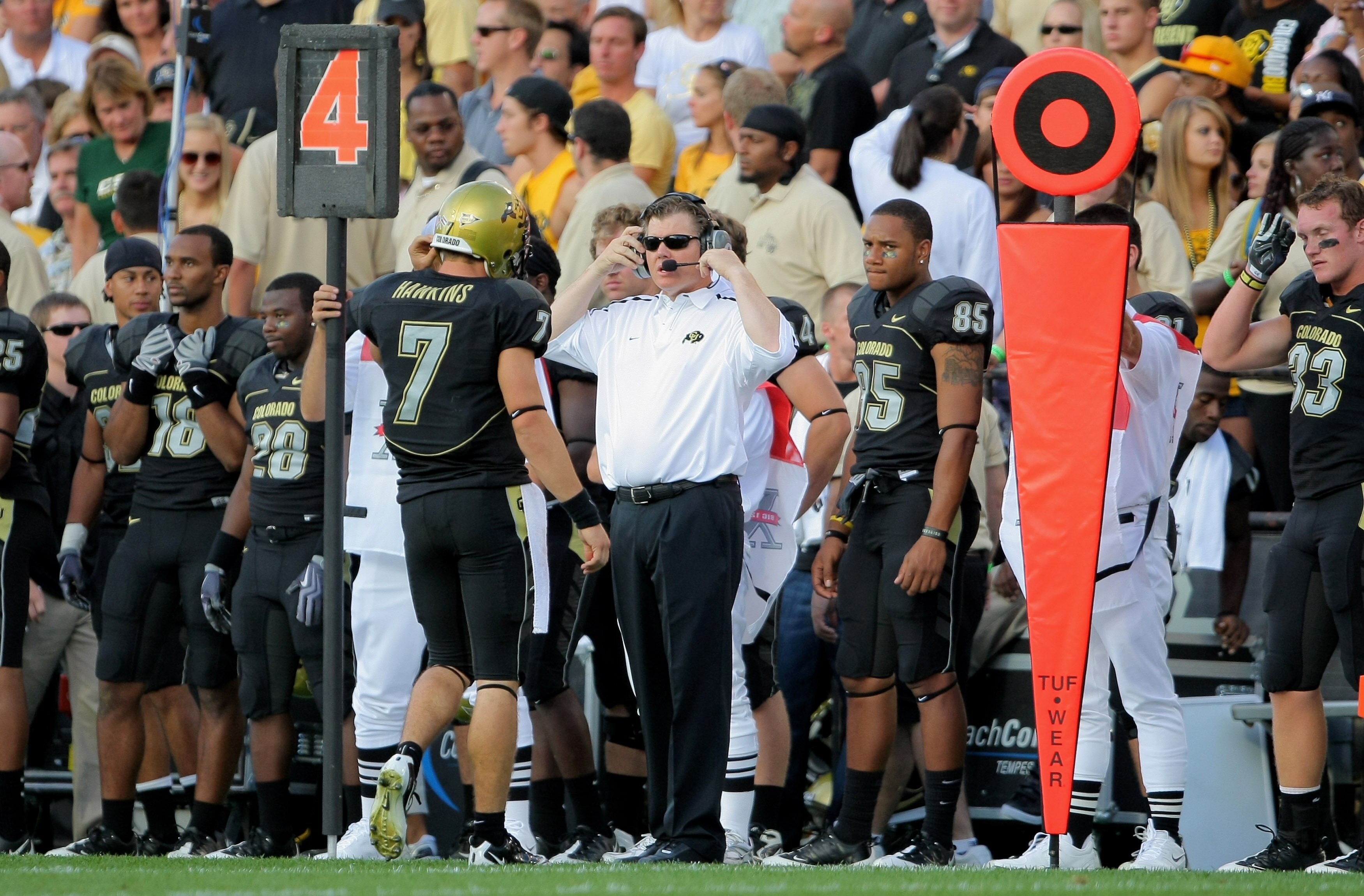 BOULDER, CO - SEPTEMBER 06:  Quarterback Cody Hawkins #7 of the Colorado Buffaloes heads to the bench and talks with his head coach, and father, Dan Hawkins after failing to convert a third down the Colorado State Rams at Folsom Field on September 6, 2009
