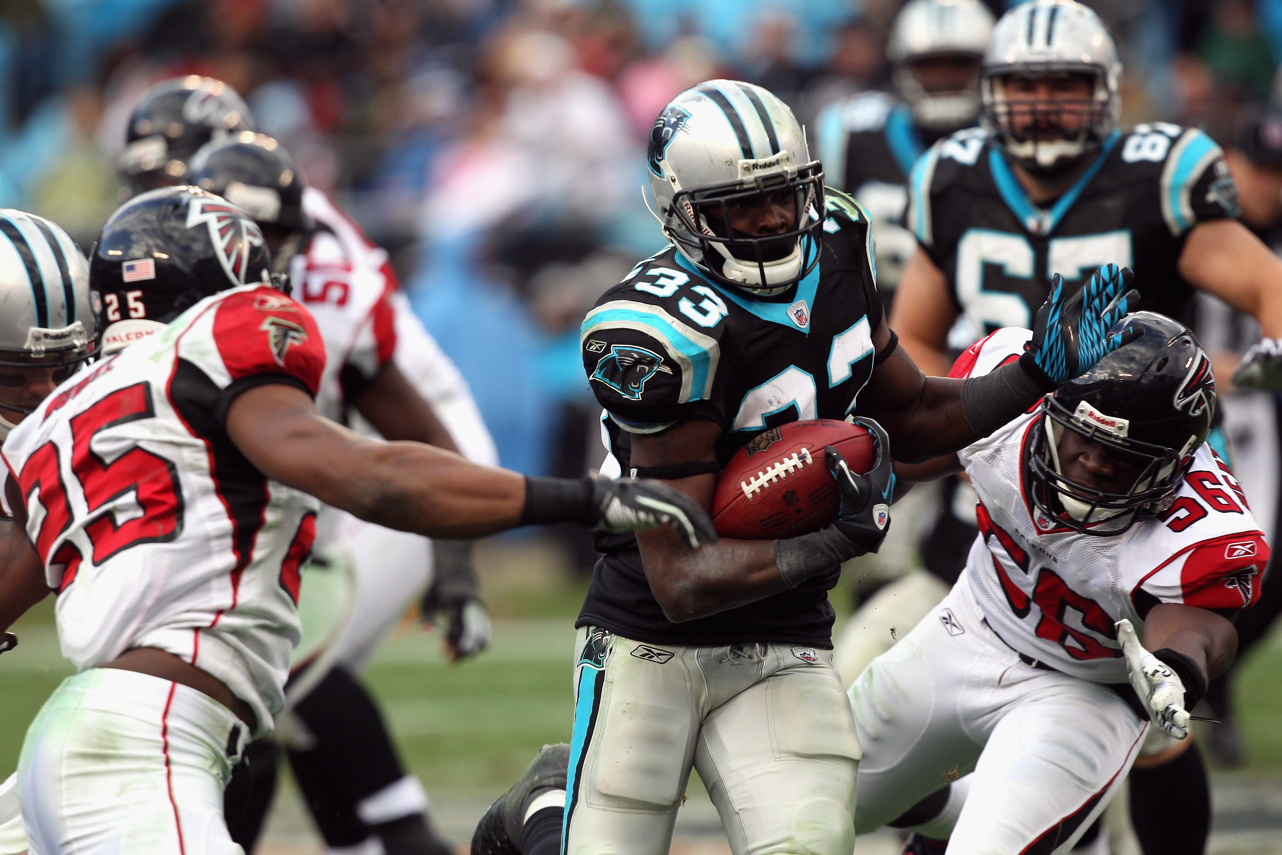 CHARLOTTE, NC - DECEMBER 12:  Sean Weatherspoon #56 of the Atlanta Falcons tries to tackle Mike Goodson #33 of the Carolina Panthers during their game at Bank of America Stadium on December 12, 2010 in Charlotte, North Carolina.  (Photo by Streeter Lecka/