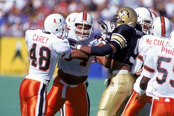 SEPTEMBER 25:  Defensive end Dwayne Johnson #94 of the University of Miami Hurricanes helps a teammate with a block during the NCAA game against University of Colorado Buffaloes on September 25, 1994.  Dwayne Johnson is also known as 'The Rock' of World W