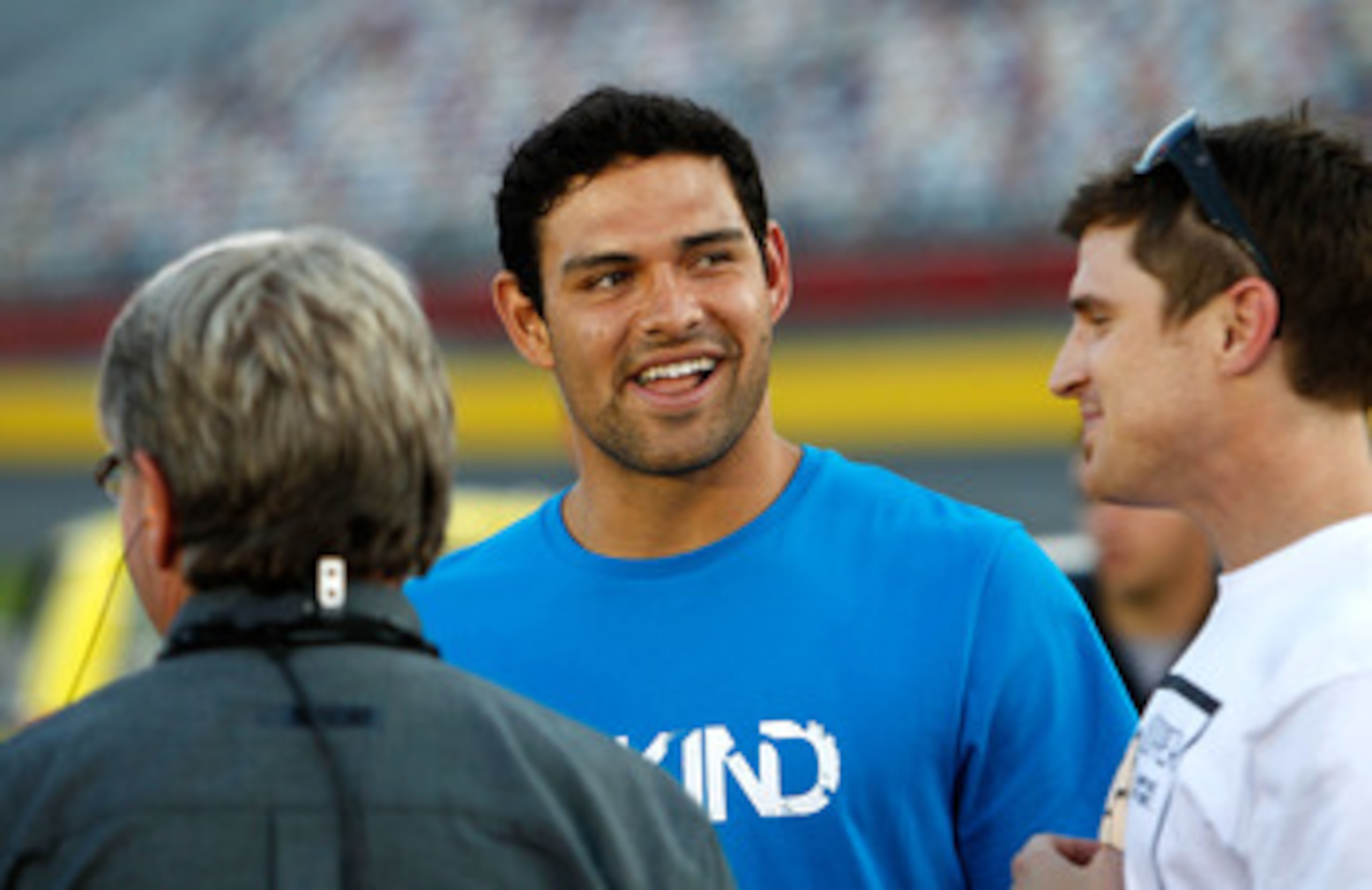 CHARLOTTE, NC - MAY 20:  (C) New York Jets quarterback Mark Sanchez stands on the starting grid prior to the NASCAR Camping World Truck Series North Carolina Education Lottery 200 at Charlotte Motor Speedway on May 20, 2011 in Charlotte, North Carolina.