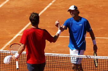 PARIS, FRANCE - MAY 23:  Stephane Robert (R) of France shakes hands with Tomas Berdych of Czech Republic as he celebrates victory in their men's singles round one match on day two of the French Open at Roland Garros on May 23, 2011 in Paris, France.  (Pho