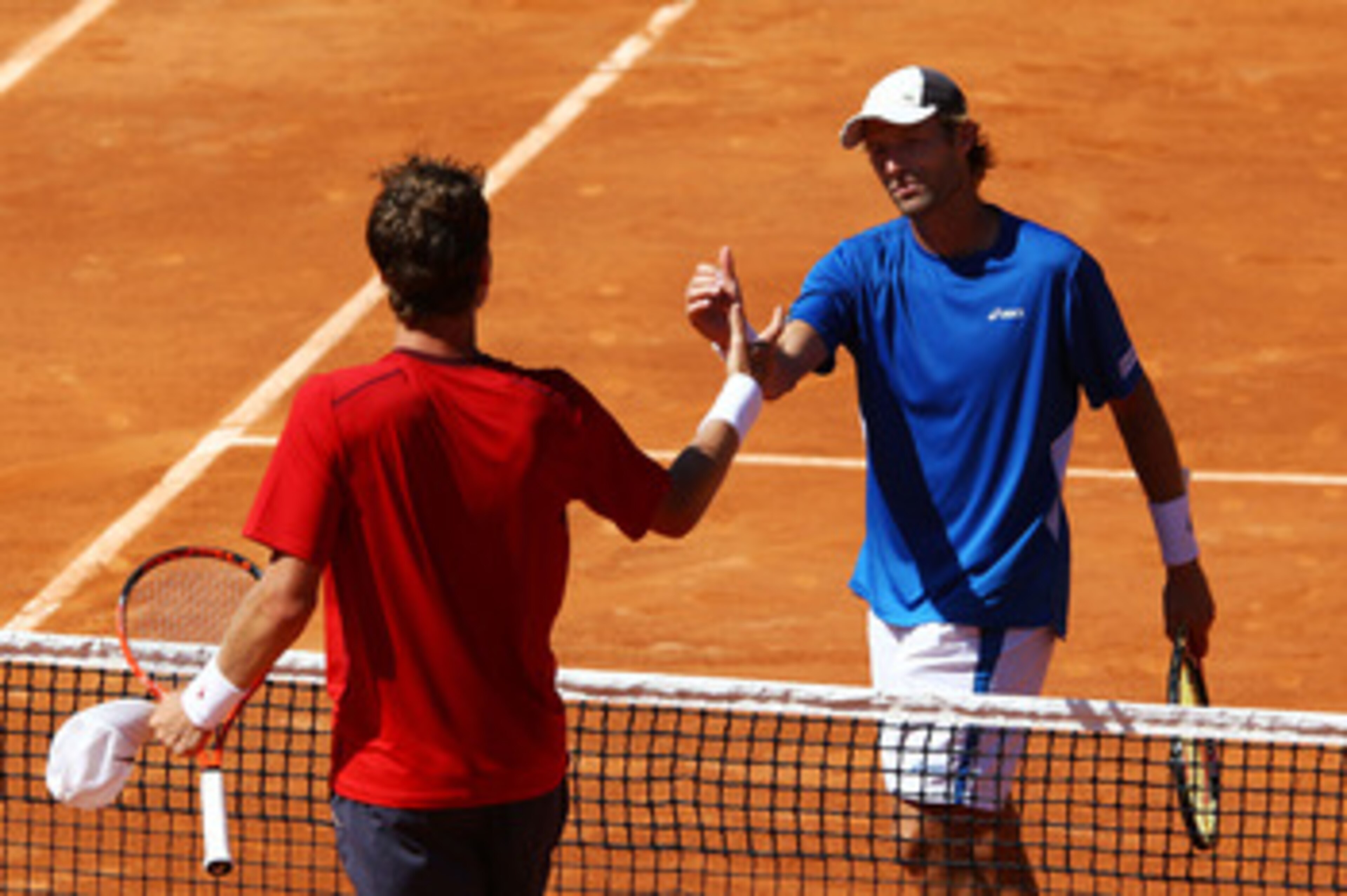 PARIS, FRANCE - MAY 23:  Stephane Robert (R) of France shakes hands with Tomas Berdych of Czech Republic as he celebrates victory in their men's singles round one match on day two of the French Open at Roland Garros on May 23, 2011 in Paris, France.  (Pho