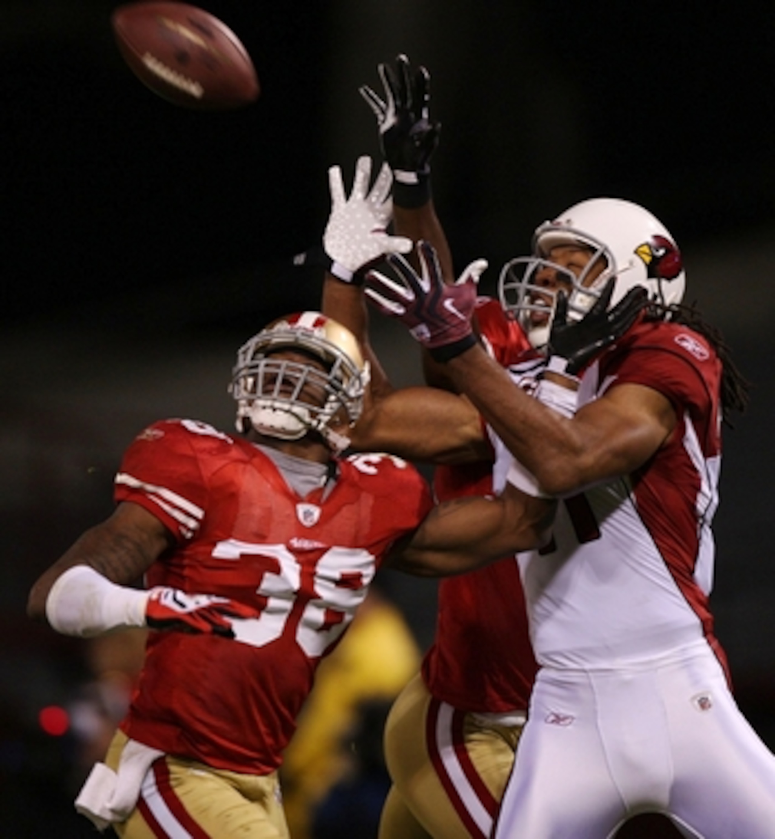 SAN FRANCISCO - DECEMBER 14:  Wide receiver Larry Fitzgerald #11 of the Arizona Cardinals goes up for a catch as it is broken up by Dashon Goldson #38 of the San Francisco 49ers in the first half at Candlestick Park on December 14, 2009 in San Francisco, 