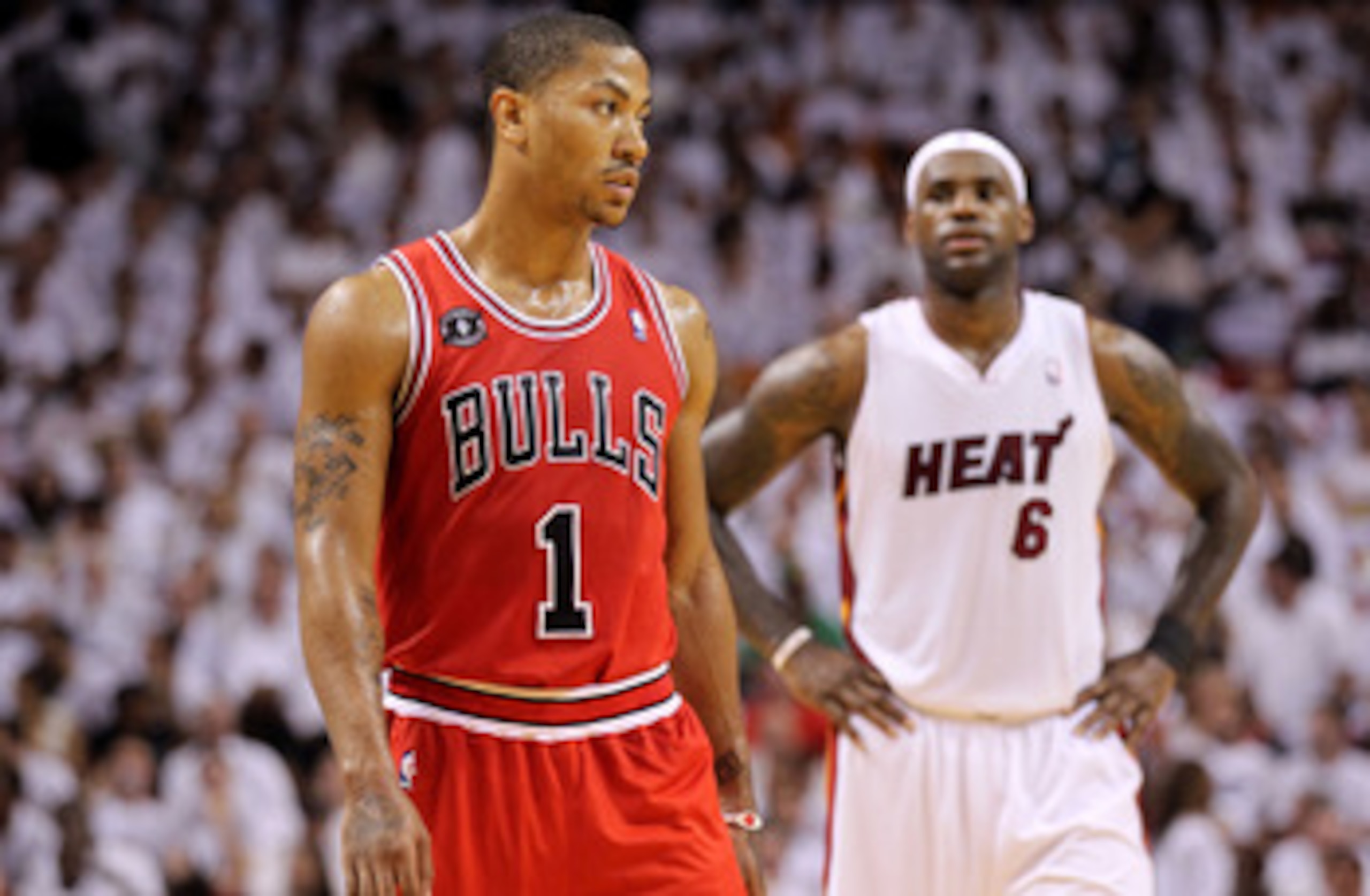 MIAMI, FL - MAY 22:  Derrick Rose #1 of the Chicago Bulls looks on as LeBron James #6 of the Miami Heat stands in the background in Game Three of the Eastern Conference Finals during the 2011 NBA Playoffs on May 22, 2011 at American Airlines Arena in Miam