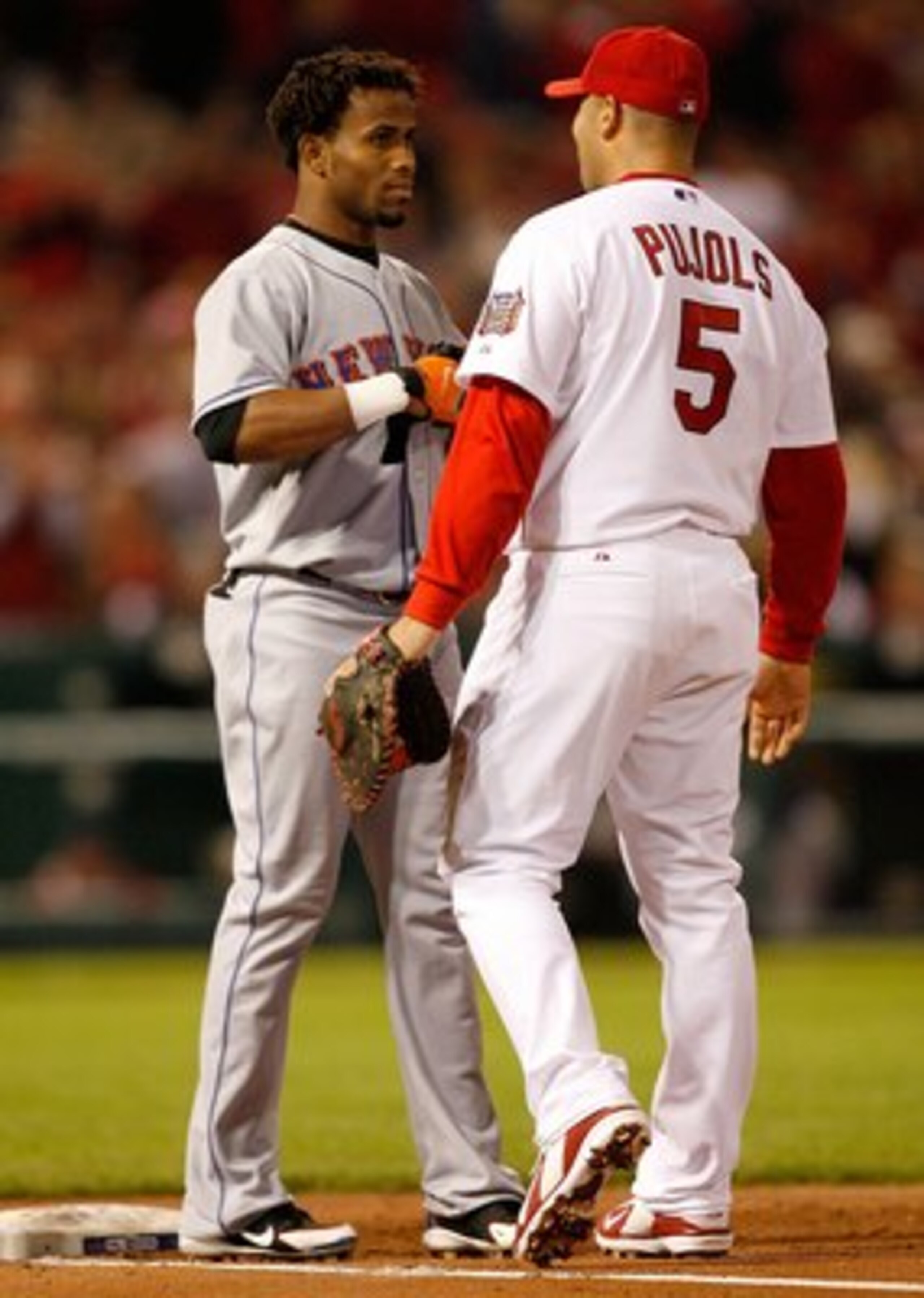 ST LOUIS - OCTOBER 15:  Albert Pujols #5 of the St. Louis Cardinals talks with Jose Reyes #7 of the New York Mets during game four of the NLCS at Busch Stadium on October 15, 2006 in St. Louis, Missouri.  (Photo by Dilip Vishwanat/Getty Images)