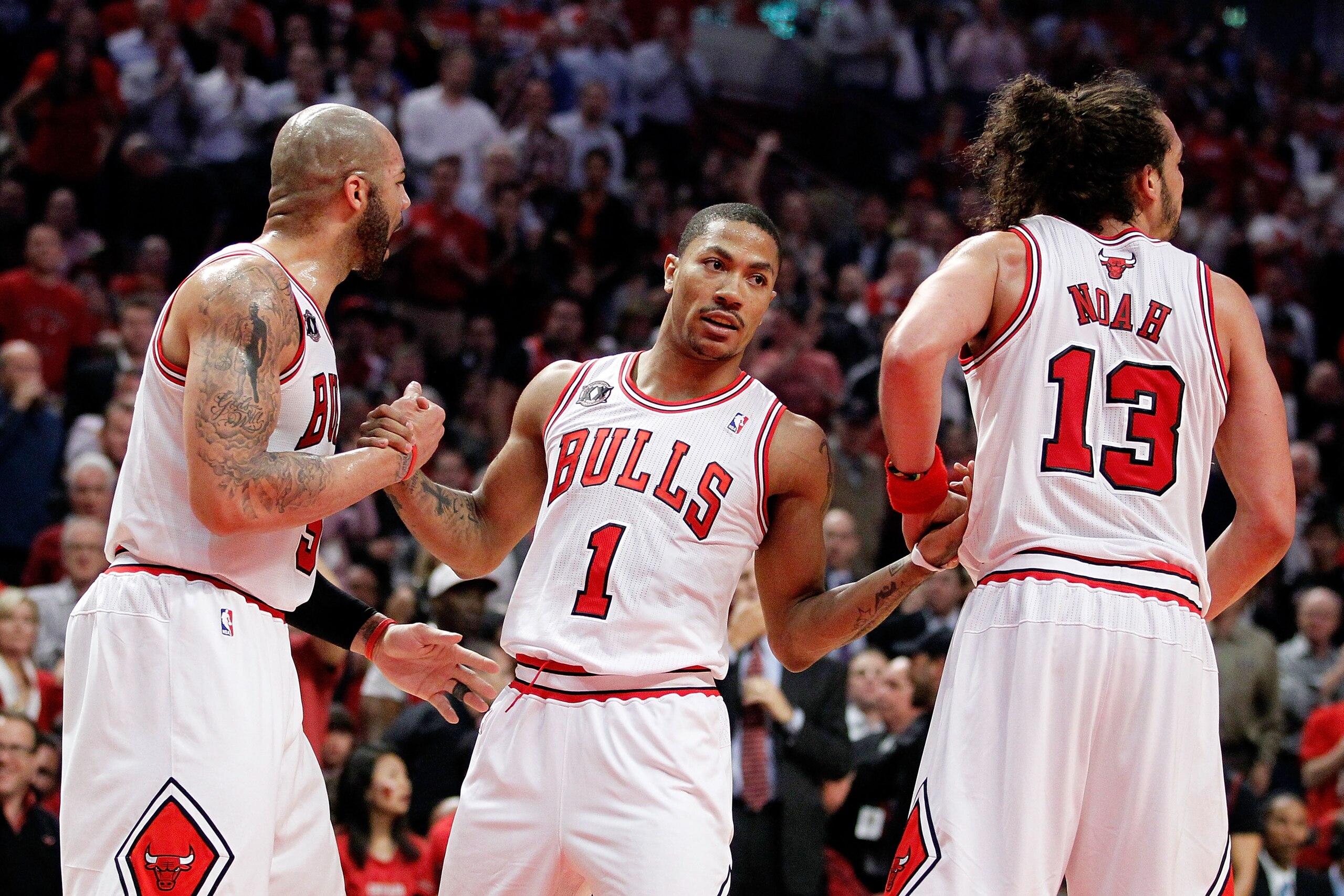 CHICAGO, IL - MAY 18:  Carlos Boozer #5 (L) and Joakim Noah #13 of the Chicago Bulls help up teammate Derrick Rose #1 after he was knocked to the court against the Miami Heat in Game Two of the Eastern Conference Finals during the 2011 NBA Playoffs on May