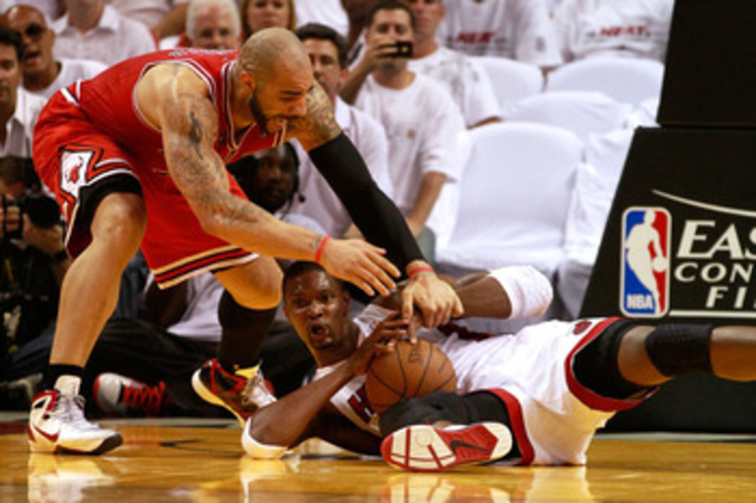 MIAMI, FL - MAY 22:  Chris Bosh #1 of the Miami Heat attempts to control a loose ball against Carlos Boozer #5 of the Chicago Bulls in Game Three of the Eastern Conference Finals during the 2011 NBA Playoffs on May 22, 2011 at American Airlines Arena in M