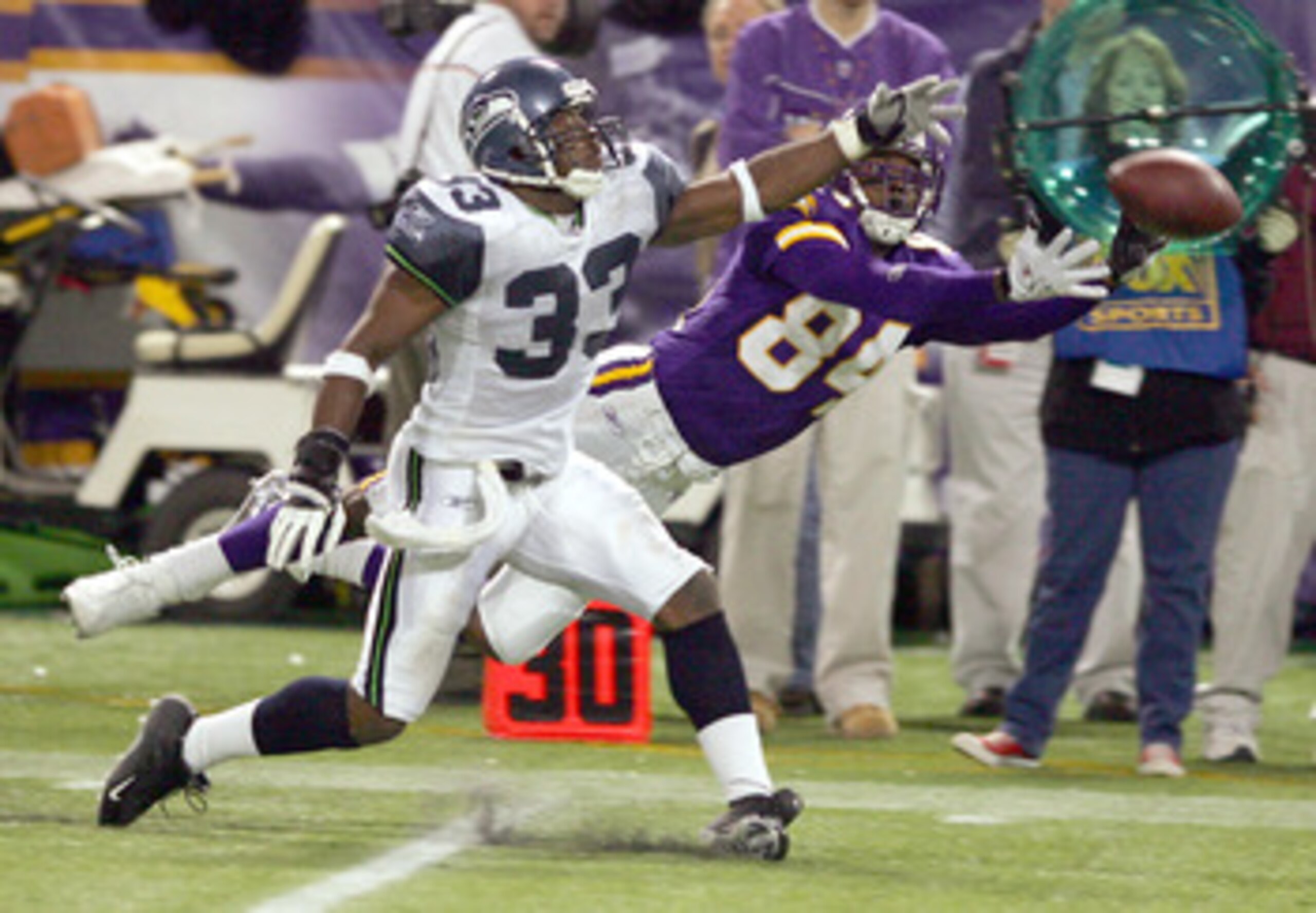 MINNEAPOLIS - DECEMBER 12: Marquand Manuel #33 of the Seattle Seahawks is called for pass interference on this play with Randy Moss #84 of the Minnesota Vikings on December 12, 2004 at the Hubert H. Humphrey Metrodome in Minneapolis, Minnesota. The Seattl
