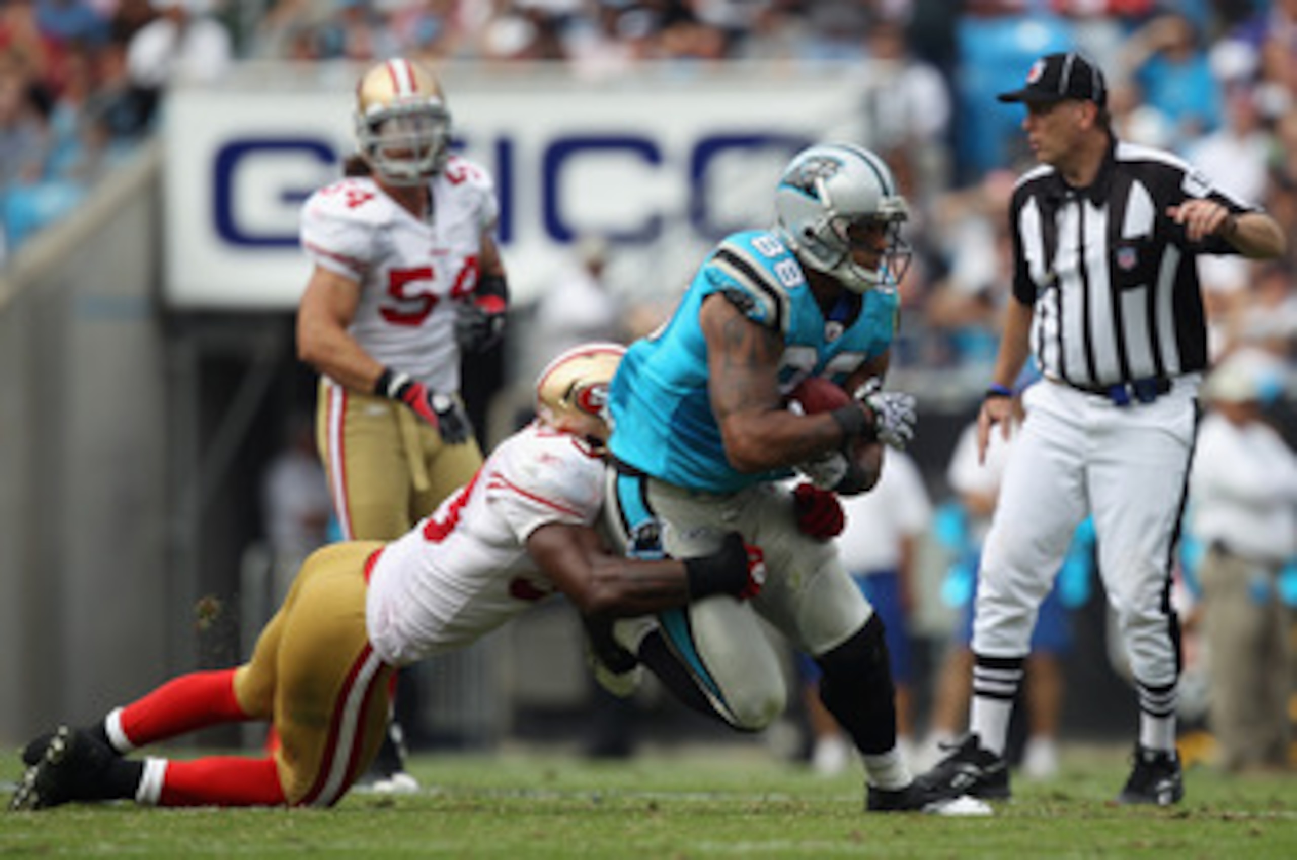 CHARLOTTE, NC - OCTOBER 24:  NaVorro Bowman #53 of the San Francisco 49ers tackles Dante Rosario #88 of the Carolina Panthers during their game at Bank of America Stadium on October 24, 2010 in Charlotte, North Carolina.  (Photo by Streeter Lecka/Getty Im