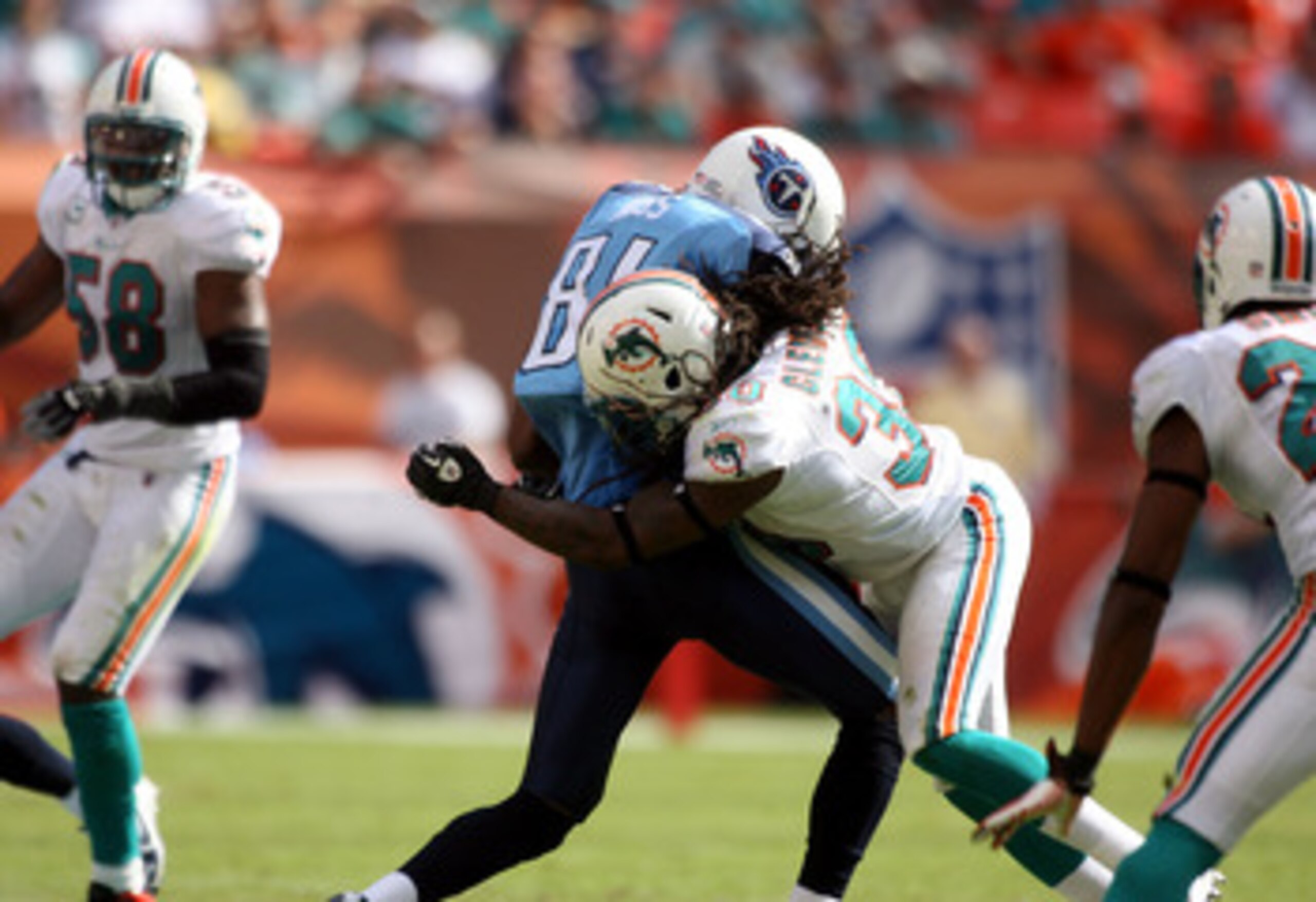 MIAMI - NOVEMBER 14:  Wide receiver Randy Moss #84 of the Tennessee Titans is seperated from the ball by Chris Clemons #30 of  the Miami Dolphins at Sun Life Stadium on November 14, 2010 in Miami, Florida.  (Photo by Marc Serota/Getty Images)
