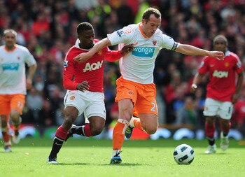 MANCHESTER, ENGLAND - MAY 22:  Charlie Adam of Balckpool battles with Patrice Evra of Manchester United during the Barclays Premier League match between Manchester United and Blackpool at Old Trafford on May 22, 2011 in Manchester, England.  (Photo by Sha