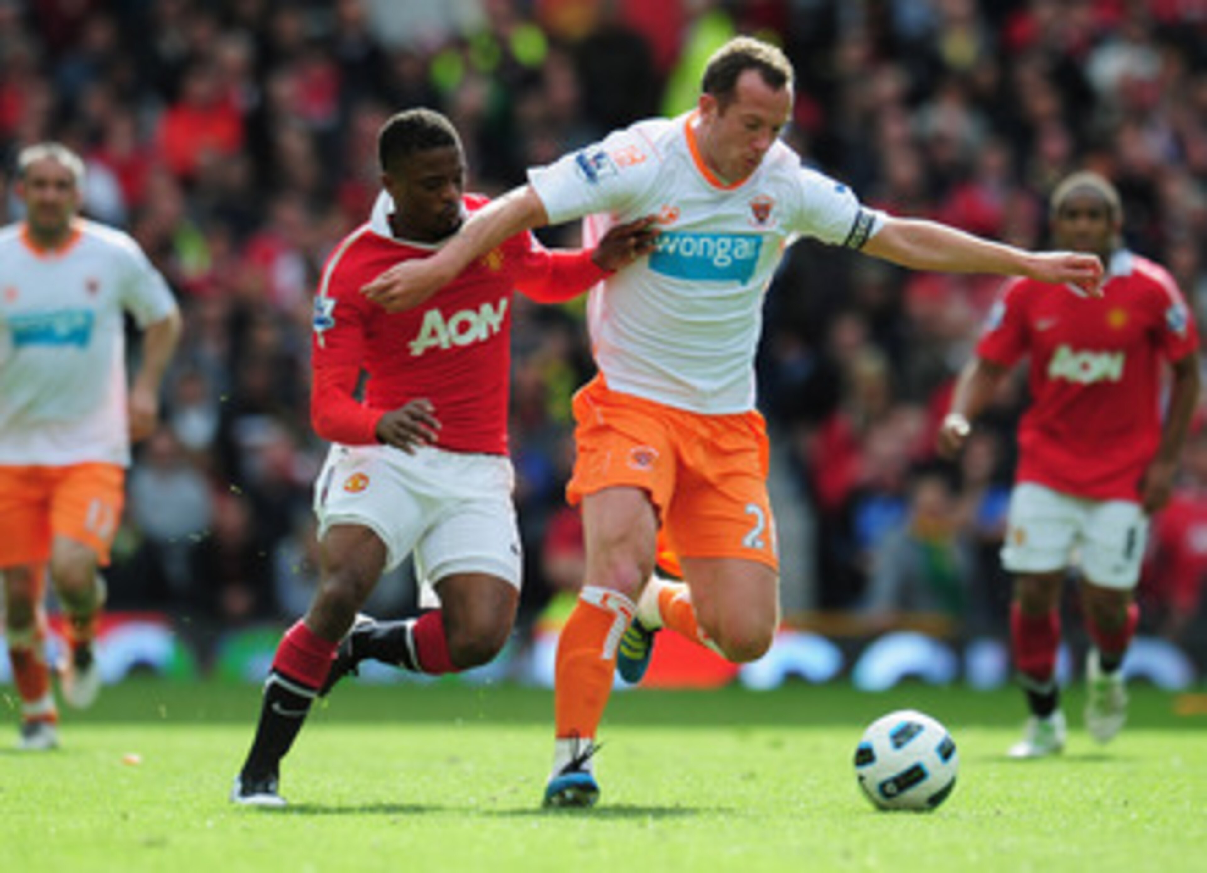 MANCHESTER, ENGLAND - MAY 22:  Charlie Adam of Balckpool battles with Patrice Evra of Manchester United during the Barclays Premier League match between Manchester United and Blackpool at Old Trafford on May 22, 2011 in Manchester, England.  (Photo by Sha