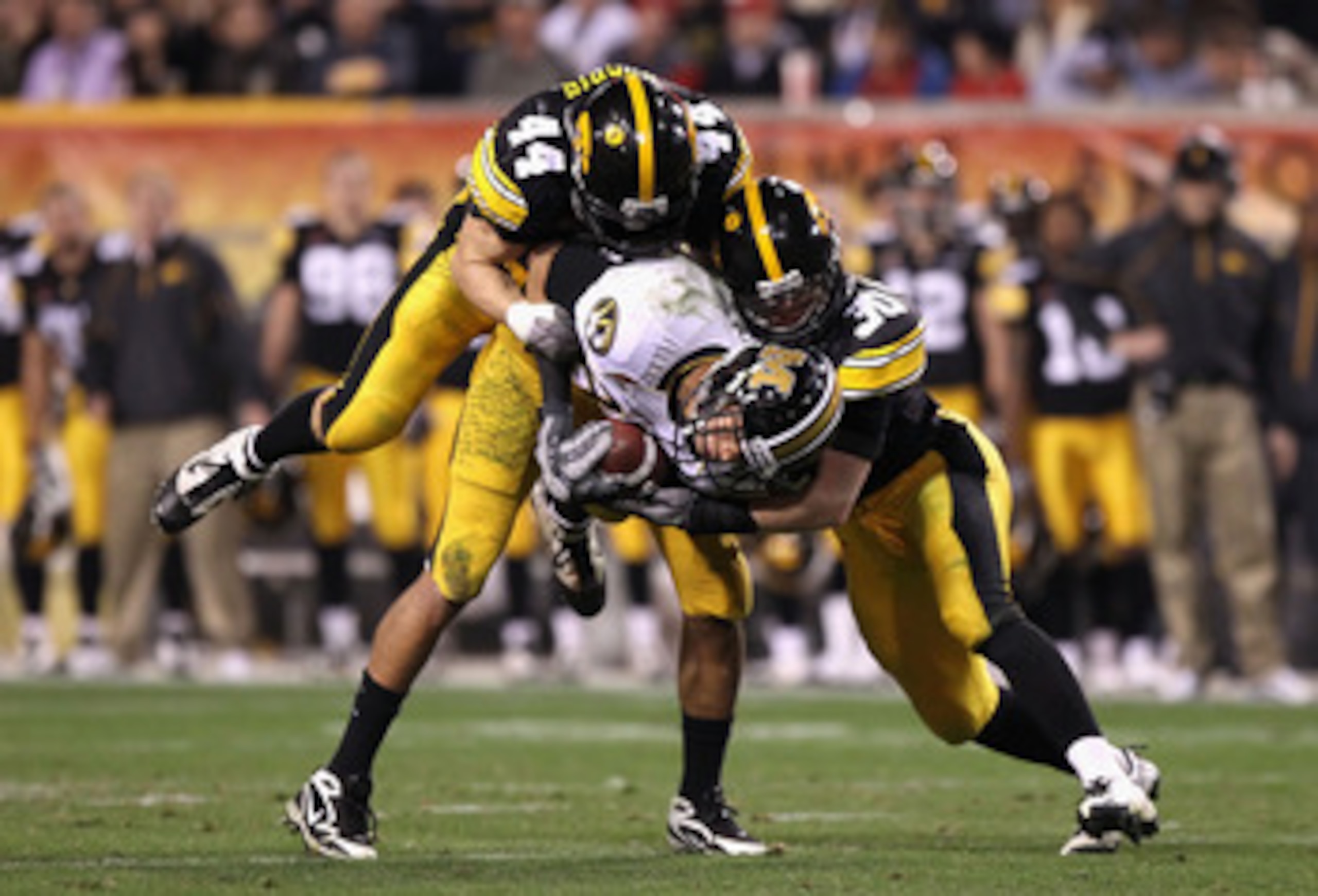 TEMPE, AZ - DECEMBER 28:  Wide receiver Michael Egnew #82 of the Missouri Tigers is tackled by James Morris #44 and Brett Greenwood #30 of the Iowa Hawkeyes after a 16 yard reception during the Insight Bowl at Sun Devil Stadium on December 28, 2010 in Tem