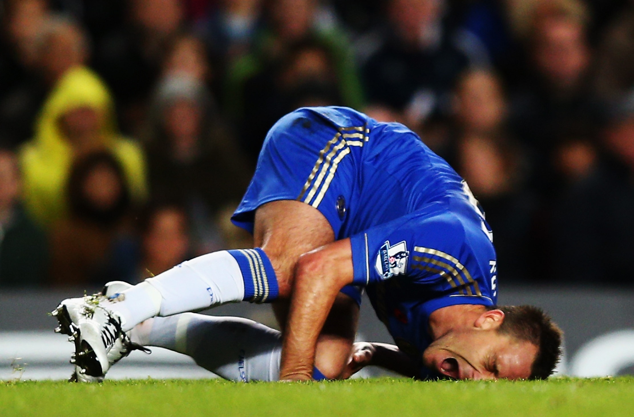 LONDON, ENGLAND - NOVEMBER 11:  John Terry of Chelsea is injured in a collision with Luis Suarez of Liverpool during the Barclays Premier League match between Chelsea and Liverpool at Stamford Bridge on November 11, 2012 in London, England.  (Photo by Cli