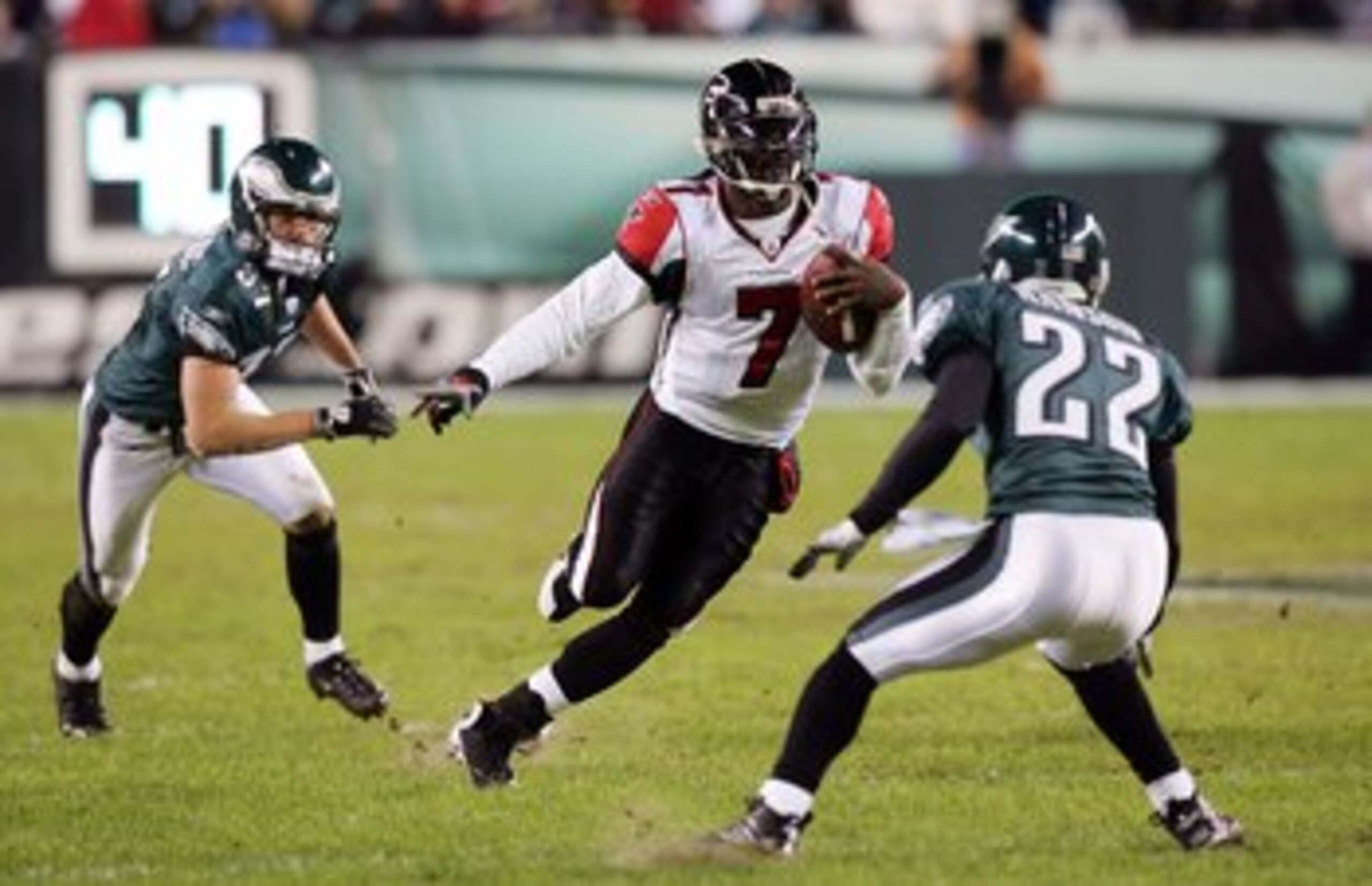 PHILADELPHIA - DECEMBER 31:  Michael Vick #7 of the Atlanta Falcons runs the ball against Sean Considine #37 and Joselio Hanson #22 of the Philadelphia Eagles in NFL action December 31, 2006 at Lincoln Financial Field in Philadelphia, Pennsylvania.  (Phot