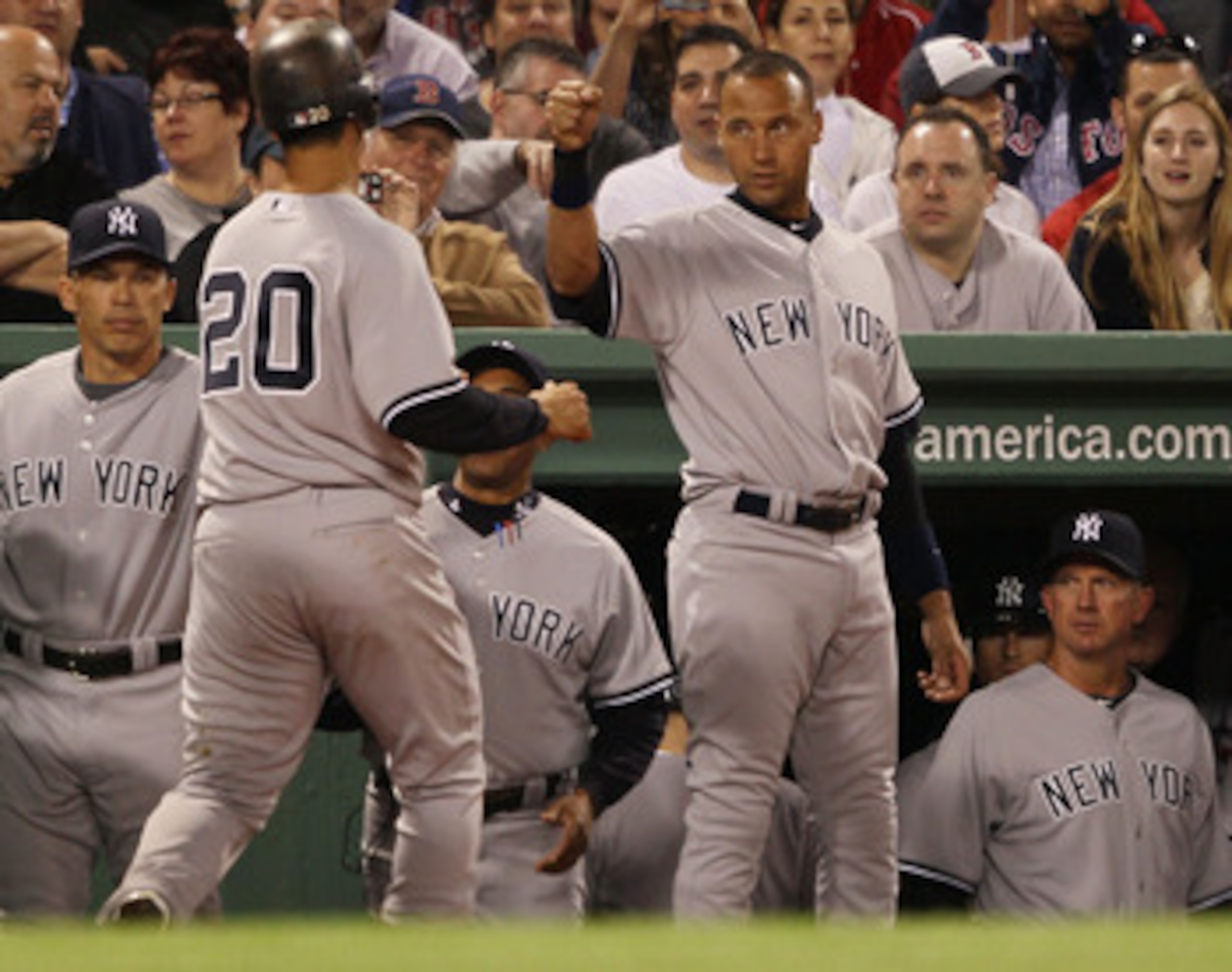 BOSTON - APRIL 04:  Jorge Posada #20 of the New York Yankees is congratulated by teammate Derek Jeter #2 after Poada hit a home run in the second inning against the Boston Red Sox on April 4, 2010 during Opening Night at Fenway Park in Boston, Massachuset