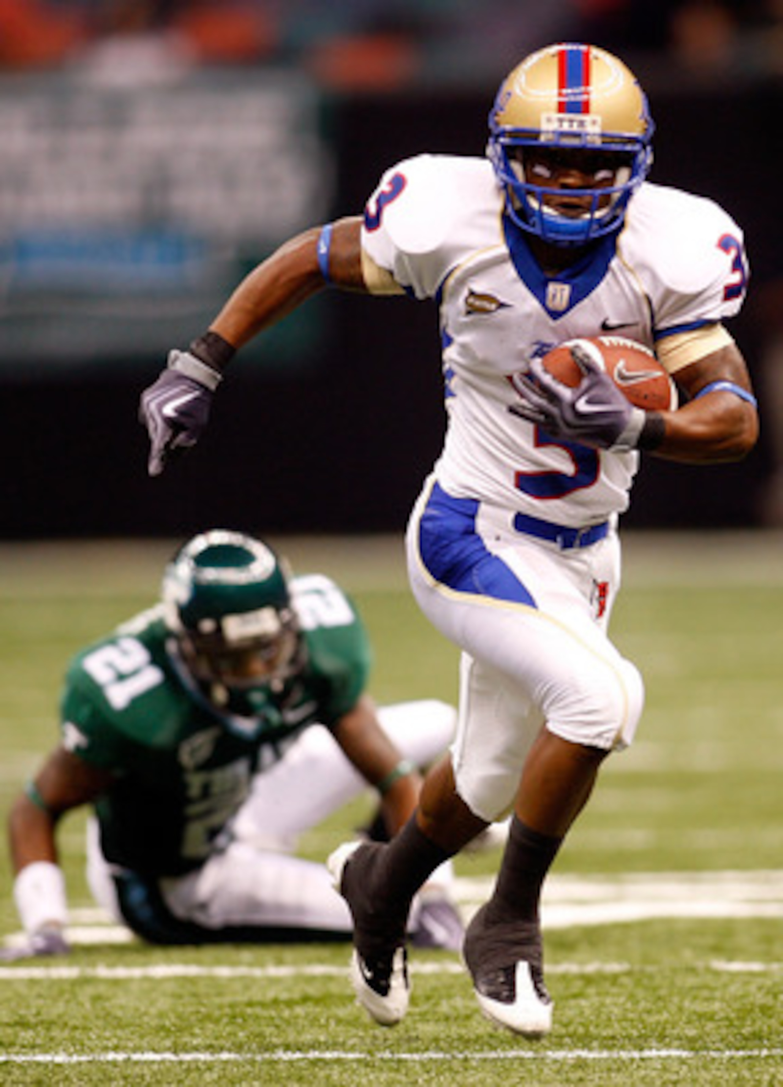 NEW ORLEANS - SEPTEMBER 04:  Damaris Johnson #3 of the Tulsa Golden Hurricanes runs past Charles Harris #21 of the Tulane Green Wave at the Louisiana Superdome on September 4, 2009 in New Orleans, Louisiana.  (Photo by Chris Graythen/Getty Images)