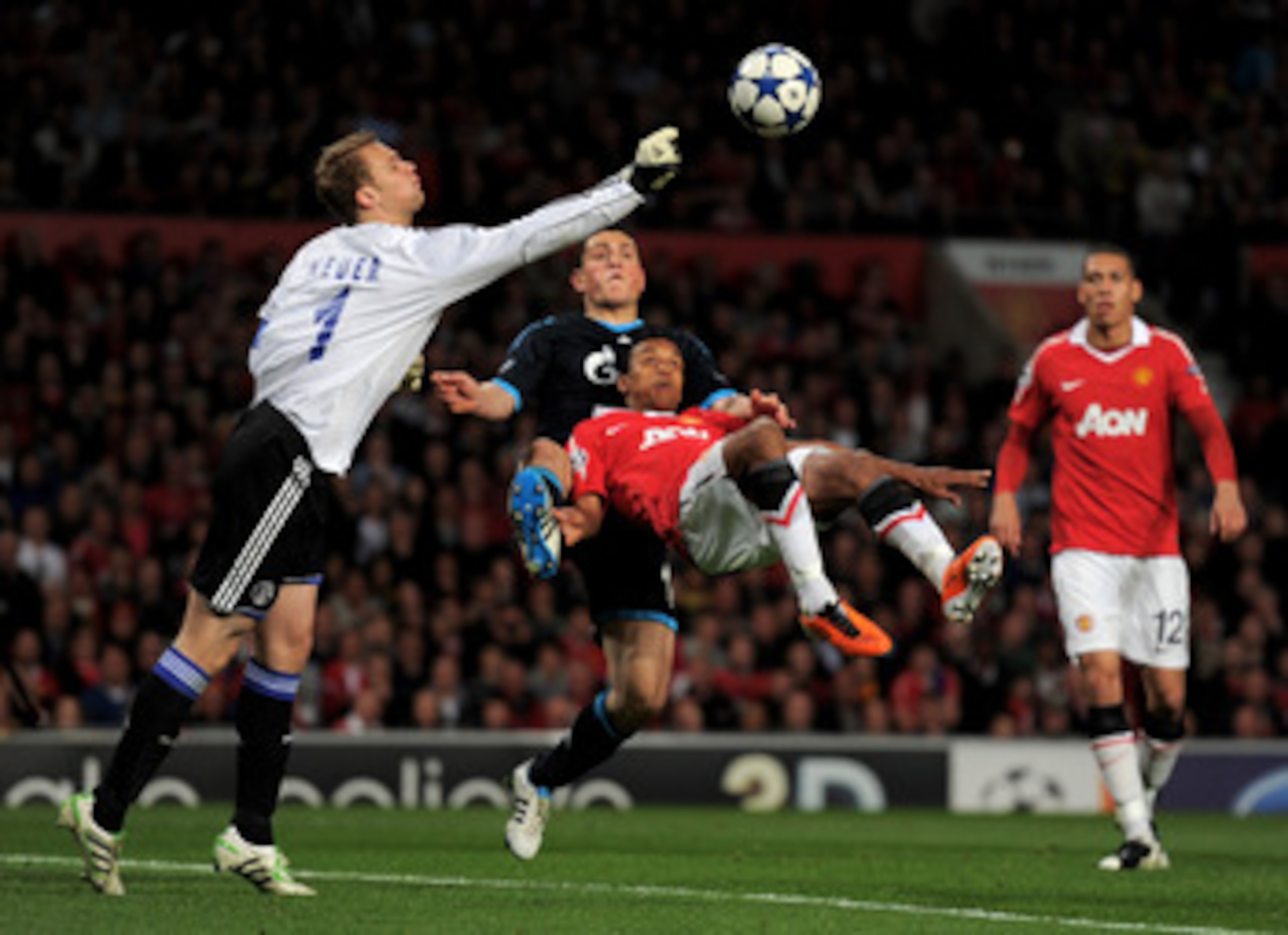 MANCHESTER, ENGLAND - MAY 04:  Manuel Neuer of Schalke punches clear under pressure from Nani of Manchester United during the UEFA Champions League Semi Final second leg match between Manchester United and Schalke at Old Trafford on May 4, 2011 in Manches