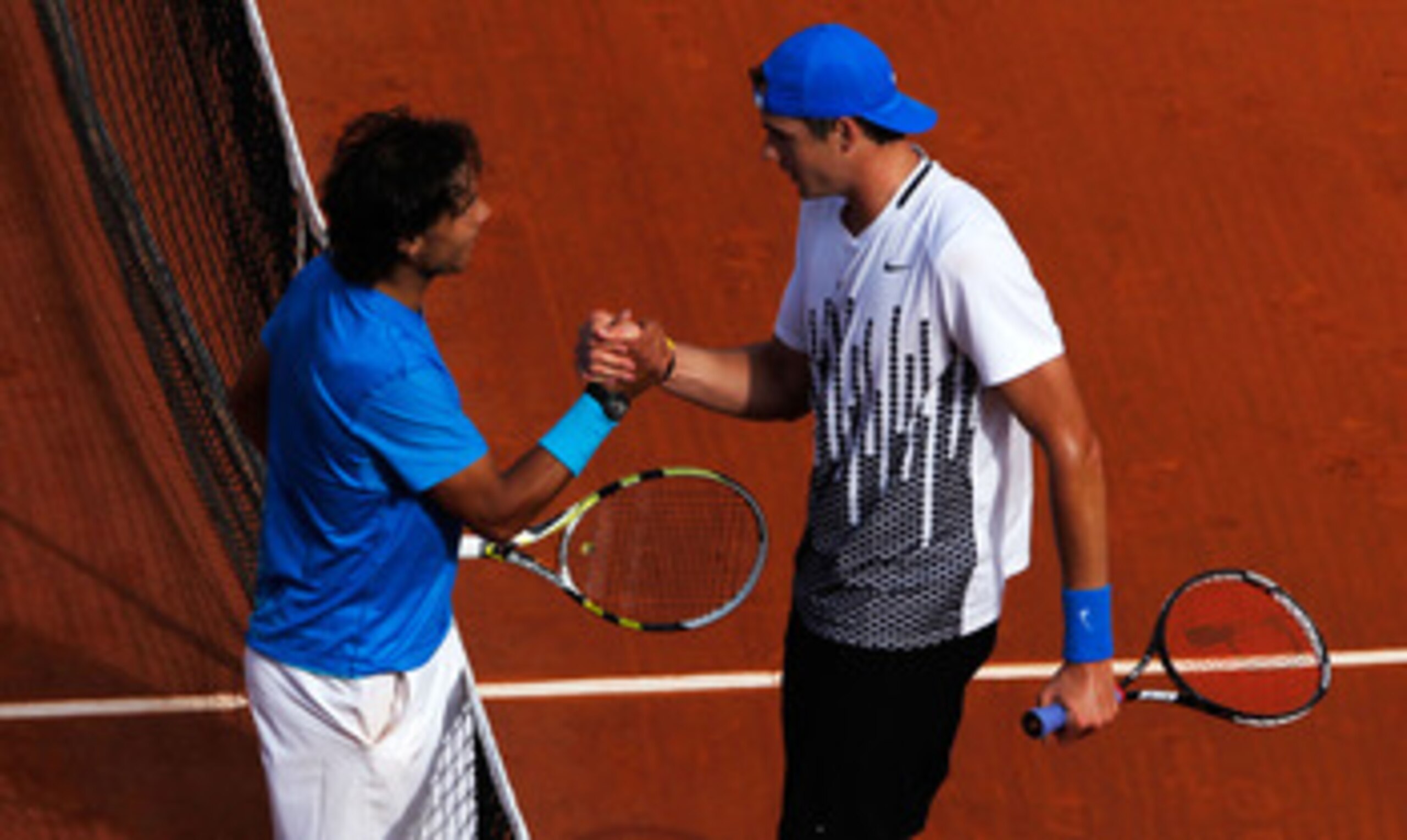 PARIS, FRANCE - MAY 24:  Rafael Nadal (L) of Spain shakes hands at the net with John Isner of USA after their men's singles round one match on day three of the French Open at Roland Garros on May 24, 2011 in Paris, France.  (Photo by Matthew Stockman/Gett