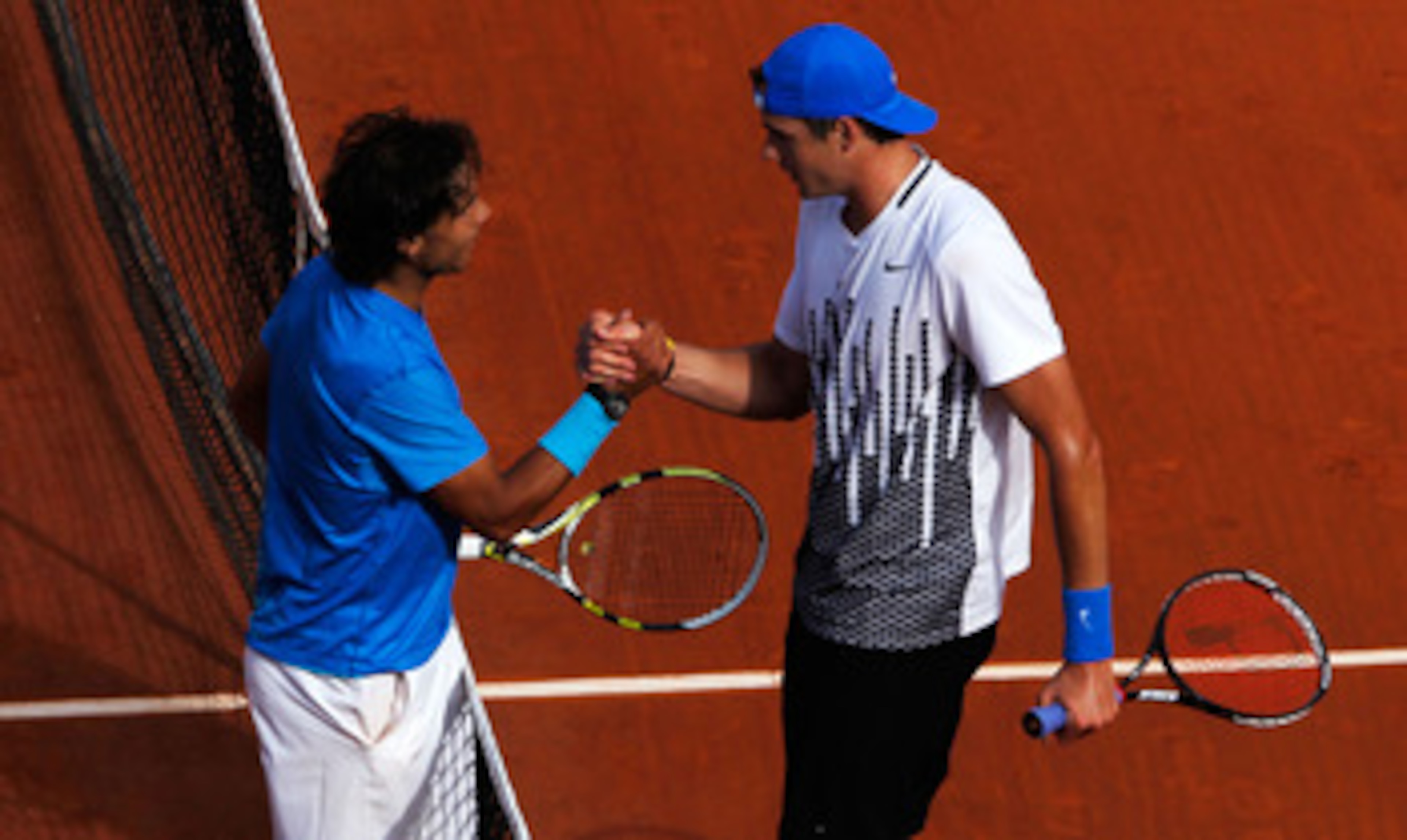 PARIS, FRANCE - MAY 24:  Rafael Nadal (L) of Spain shakes hands at the net with John Isner of USA after their men's singles round one match on day three of the French Open at Roland Garros on May 24, 2011 in Paris, France.  (Photo by Matthew Stockman/Gett