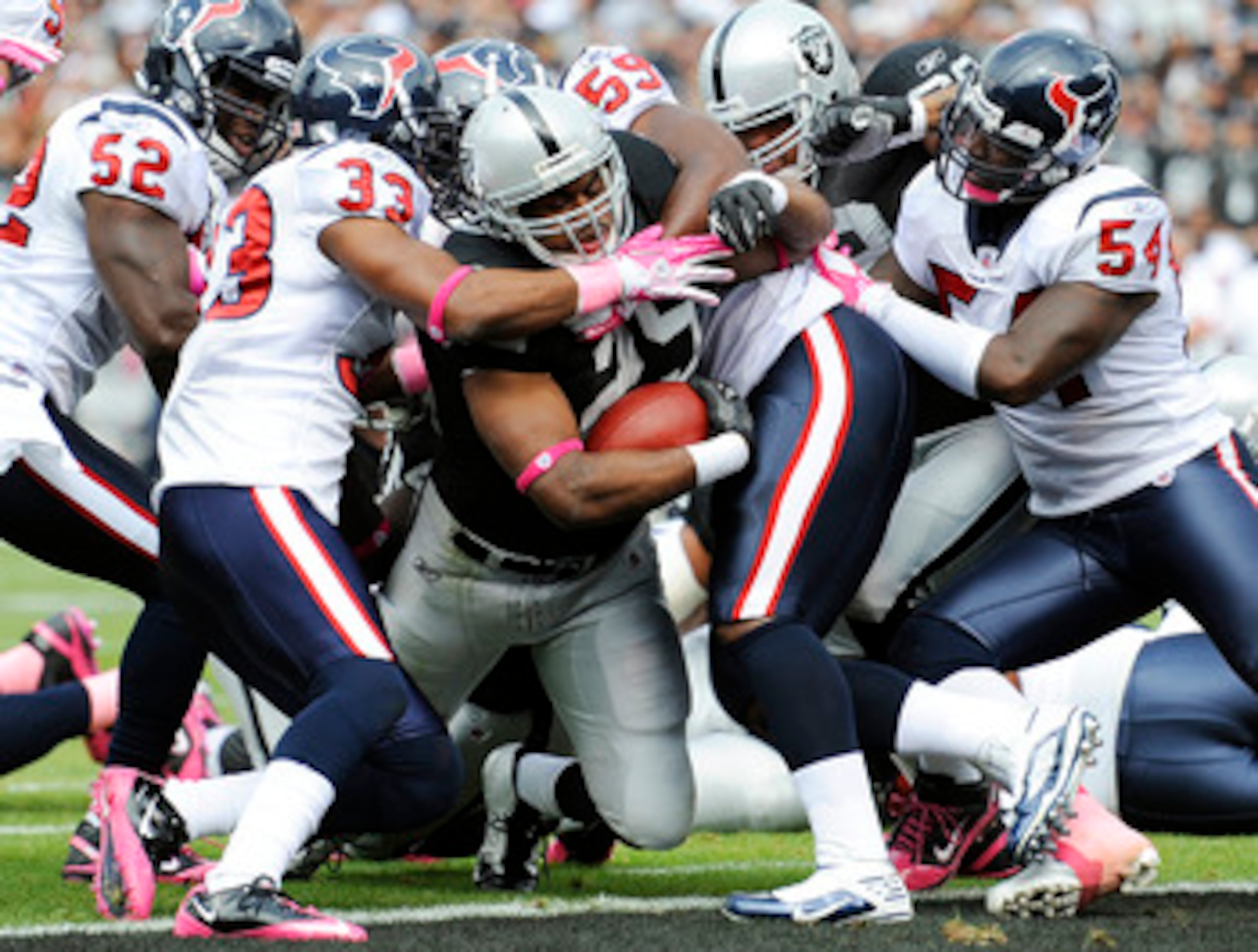 OAKLAND, CA - OCTOBER 3: Running back Michael Bush #29 of the Oakland Raiders drags Troy Nolan #33 and DeMeco Ryans #59 of the Houston Texans into the endzone for a touchdown during an NFL football game October 3, 2010 at The Oakland-Alameda County Colise