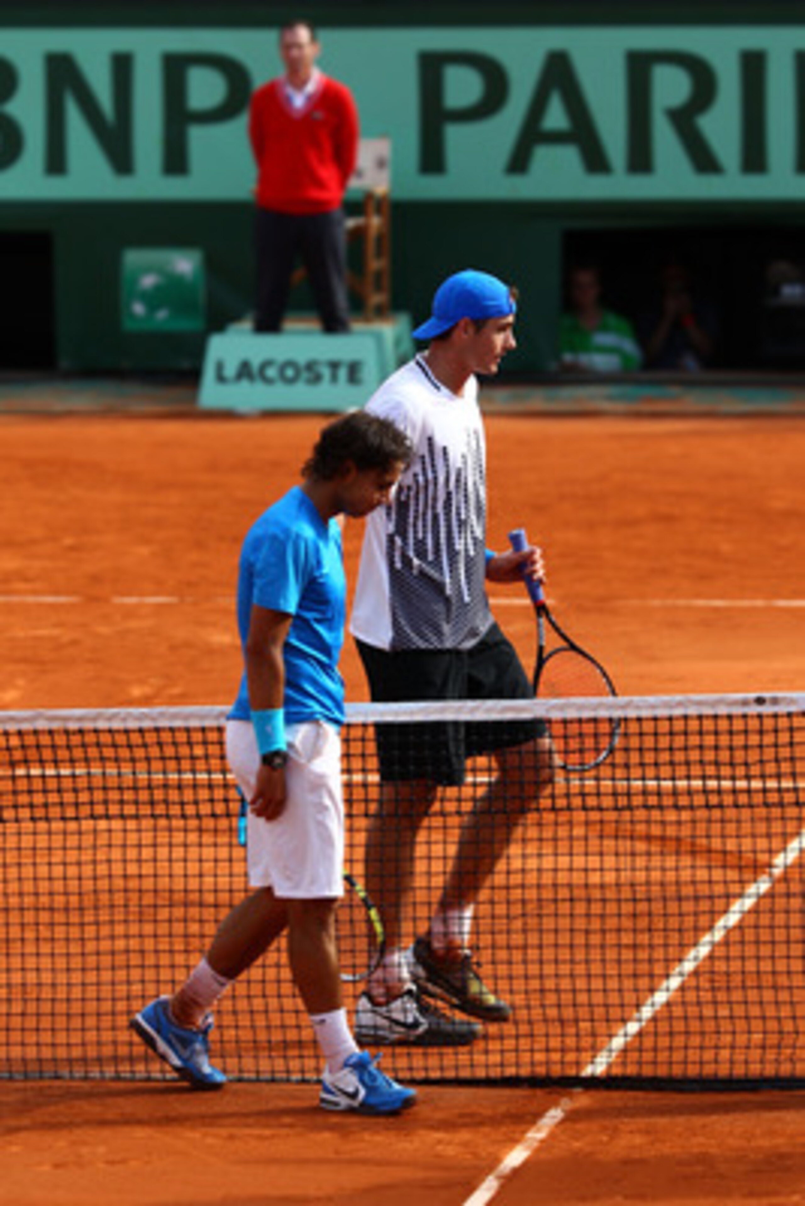 PARIS, FRANCE - MAY 24:  Rafael Nadal (L) of Spain meets John Isner of USA at the net after their men's singles round one match on day three of the French Open at Roland Garros on May 24, 2011 in Paris, France.  (Photo by Clive Brunskill/Getty Images)