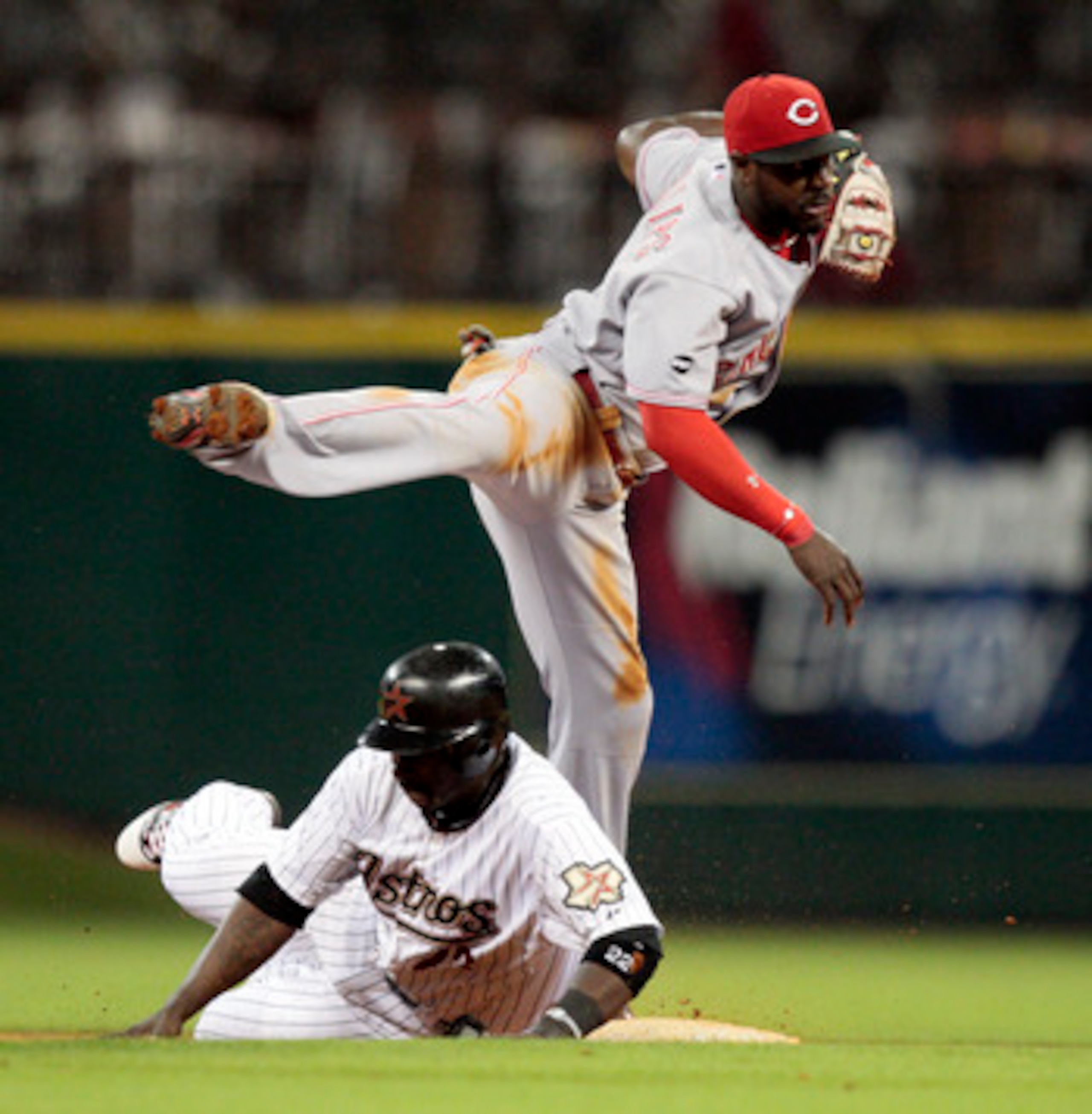 HOUSTON - MAY 09:  Second baseman Brandon Phillips #4 of the Cincinnati Reds throws to first as Bill Hall #22 of the Houston Astros slides into him at Minute Maid Park on May 9, 2011 in Houston, Texas.  (Photo by Bob Levey/Getty Images)