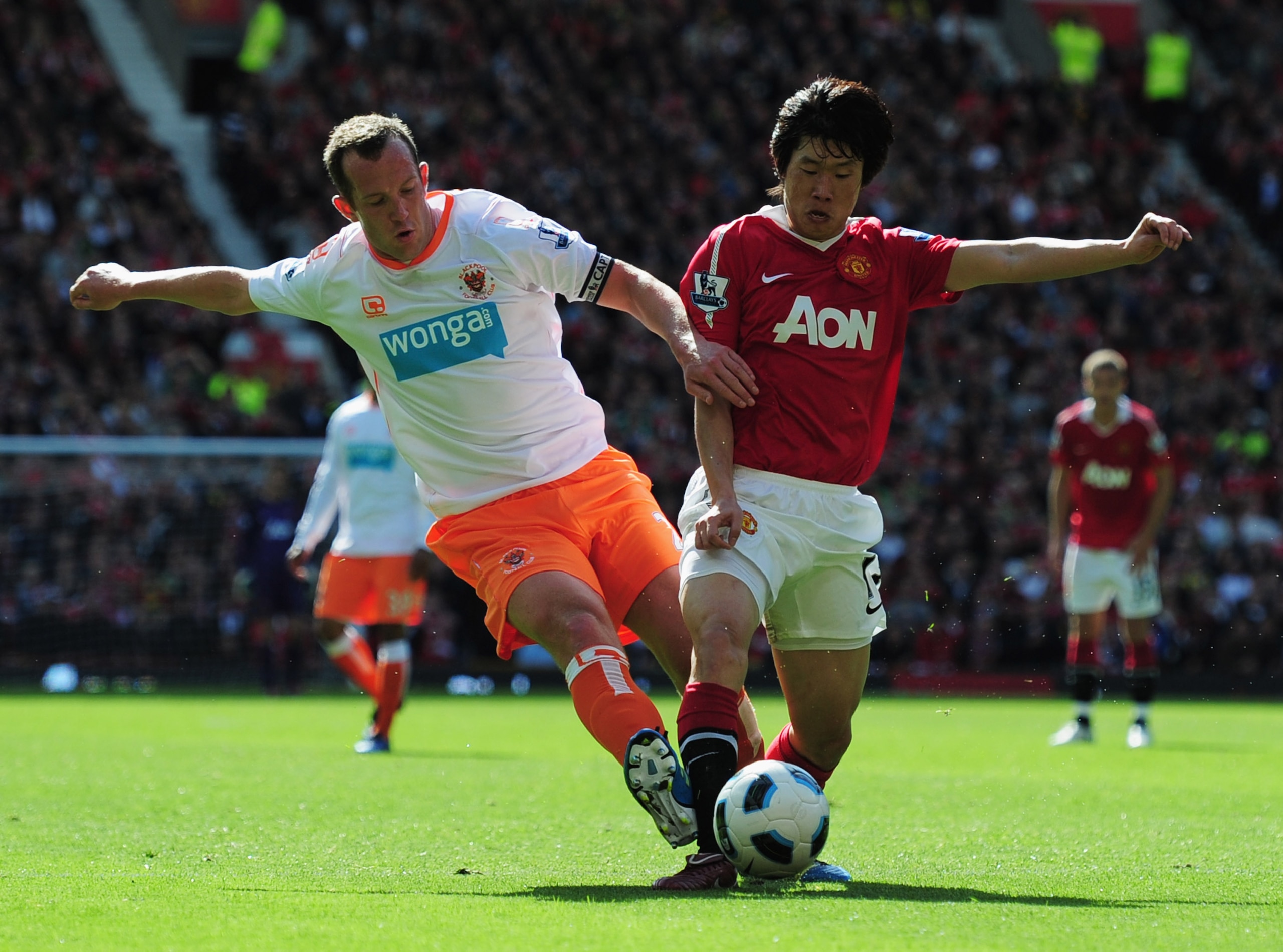 MANCHESTER, ENGLAND - MAY 22:  Park Ji-Sung of Manchester United is tackled by Charlie Adam of Blackpool during the Barclays Premier League match between Manchester United and Blackpool at Old Trafford on May 22, 2011 in Manchester, England.  (Photo by Sh