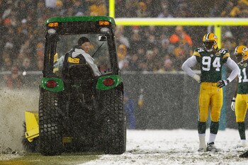 GREEN BAY, WI - JANUARY 12:  Defensive end Kabeer Gbaja-Biamila #94 of the Green Bay Packers watches as a snow plow drives down the middle of the field in the fourth quarter of the game against the Seattle Seahawks during the NFC divisional playoff game o