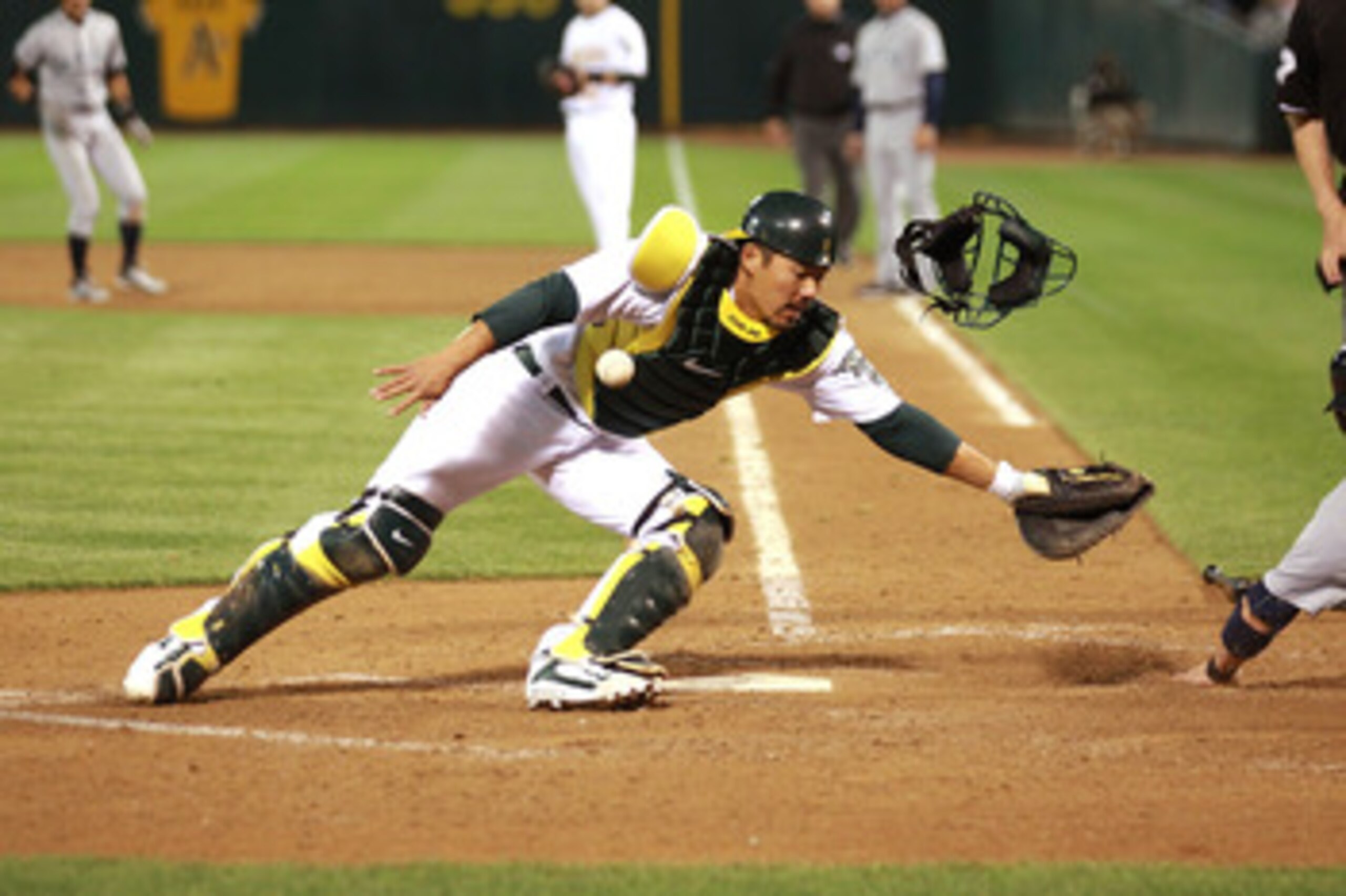 OAKLAND, CA - APRIL 01:  Kurt Suzuki #8 of the Oakland Athletics fails to tag out Brendan Ryan #26 of the Seattle Mariners on a single hit by Ichiro Suzuki during an opening day game of Major League Baseball at the Oakland-Alameda County Coliseum on April