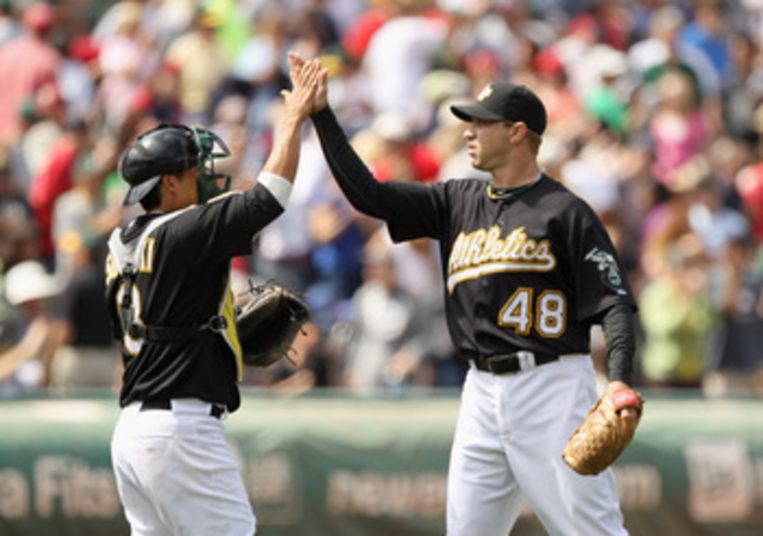 OAKLAND, CA - JULY 21:  Michael Wuertz #48 of the Oakland Athletics is congratulated by Kurt Suzuki #8 after they beat the Boston Red Sox at the Oakland-Alameda County Coliseum on July 21, 2010 in Oakland, California.  (Photo by Ezra Shaw/Getty Images)