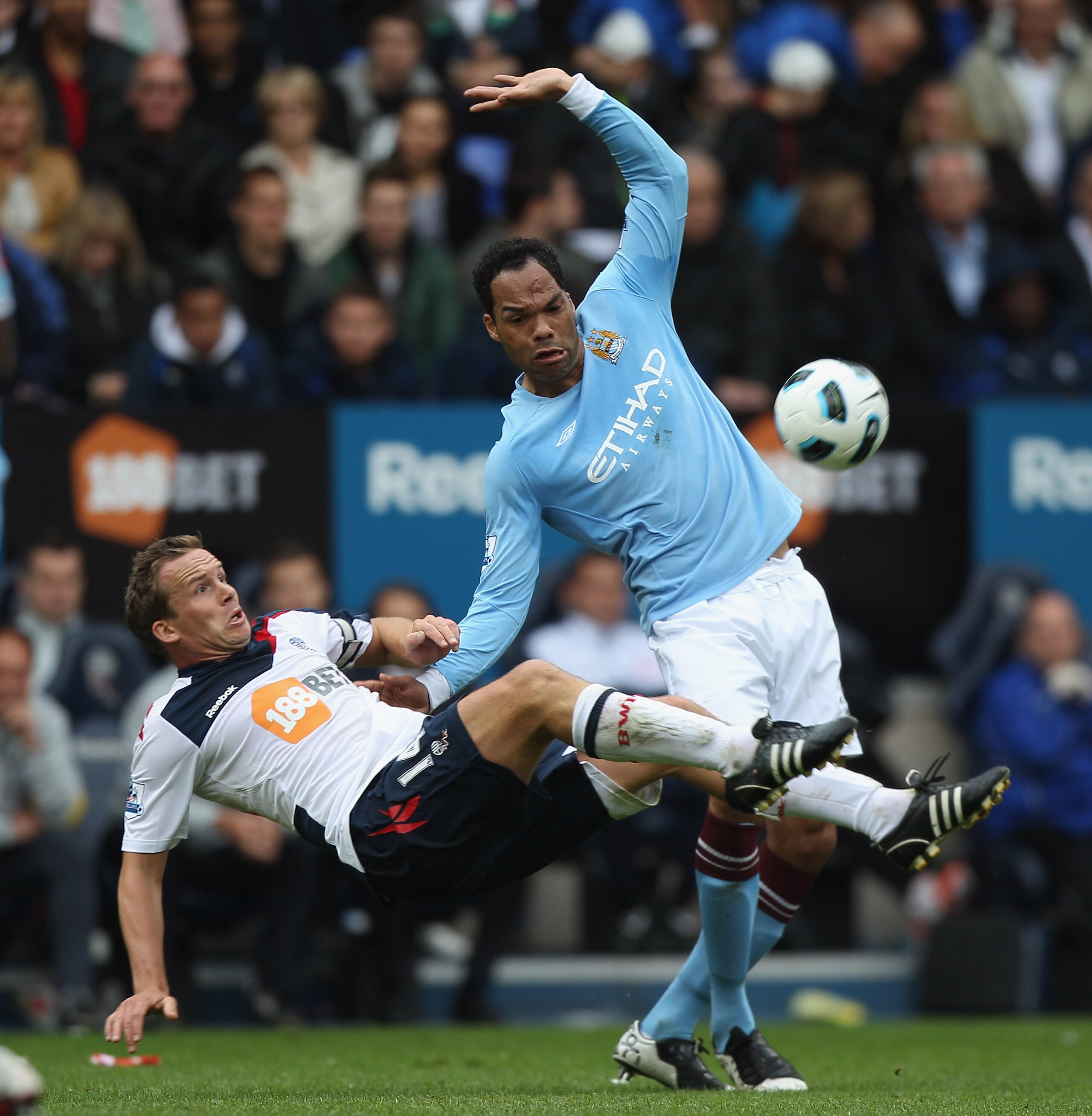 BOLTON, ENGLAND - MAY 22:  Kevin Davies (L) of Bolton falls under the challenge of Joleon Lescott (R) during the Barclays Premier League match between  Bolton Wanderers and Manchester City at the Reebok Stadium on May 22, 2011 in Bolton, England.  (Photo