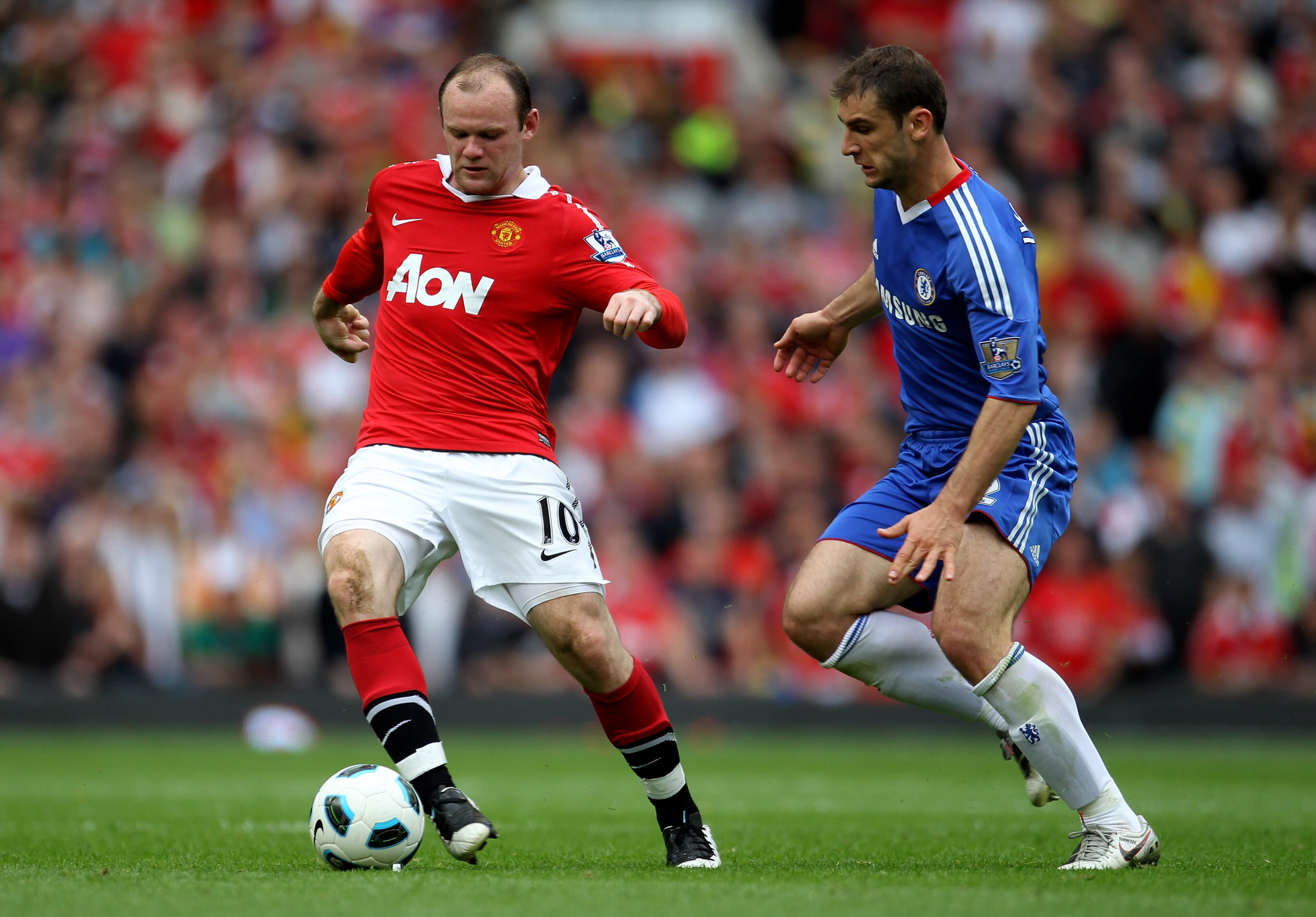 MANCHESTER, ENGLAND - MAY 08:  Wayne Rooney of Manchester United competes with Branislav Ivanovic of Chelsea during the Barclays Premier League match between Manchester United and Chelsea at Old Trafford on May 8, 2011 in Manchester, England.  (Photo by A