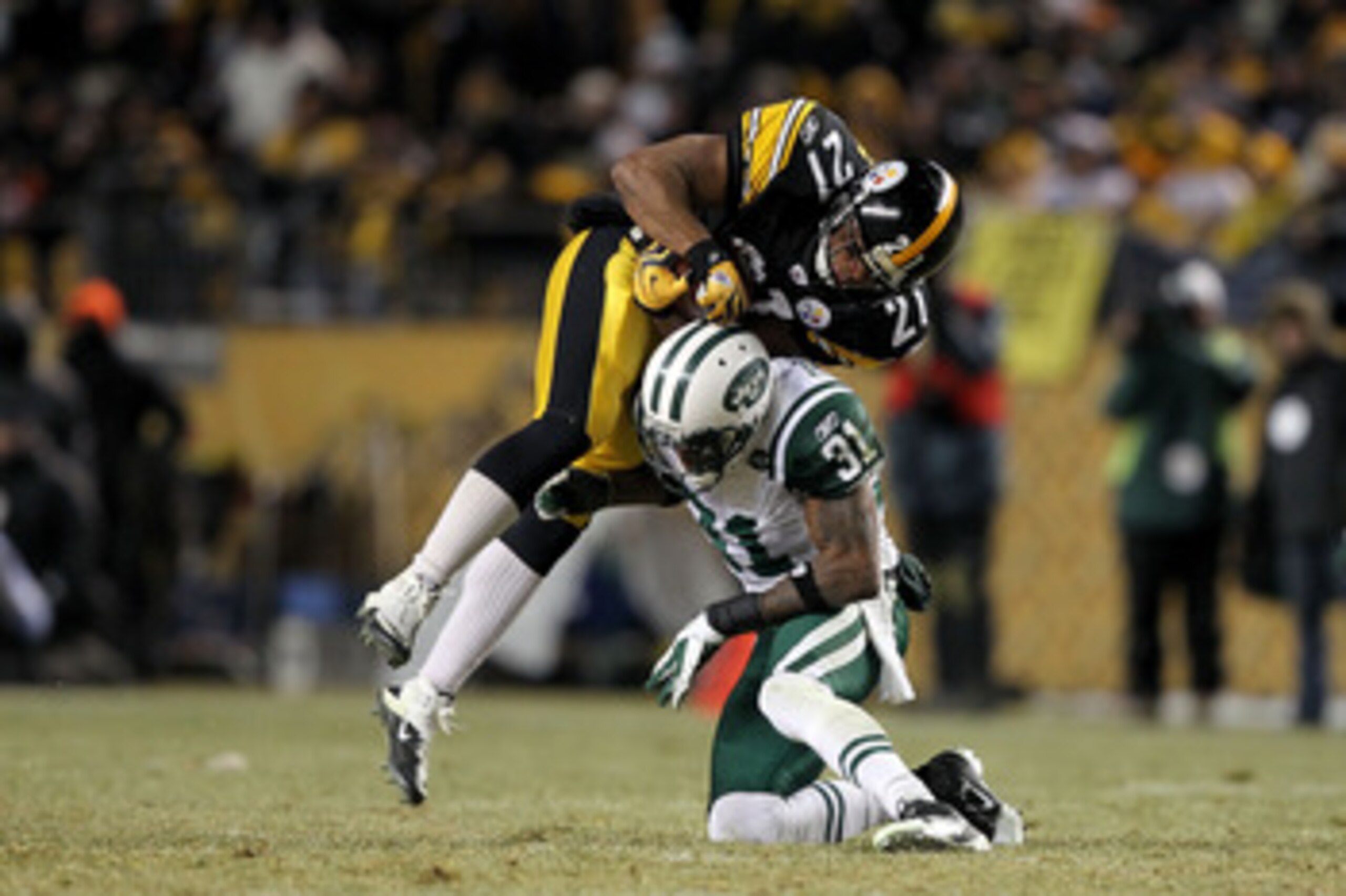 PITTSBURGH, PA - JANUARY 23:  Mewelde Moore #21 of the Pittsburgh Steelers catches a pass over Antonio Cromartie #31 of the New York Jets in the third quarter of the 2011 AFC Championship game at Heinz Field on January 23, 2011 in Pittsburgh, Pennsylvania