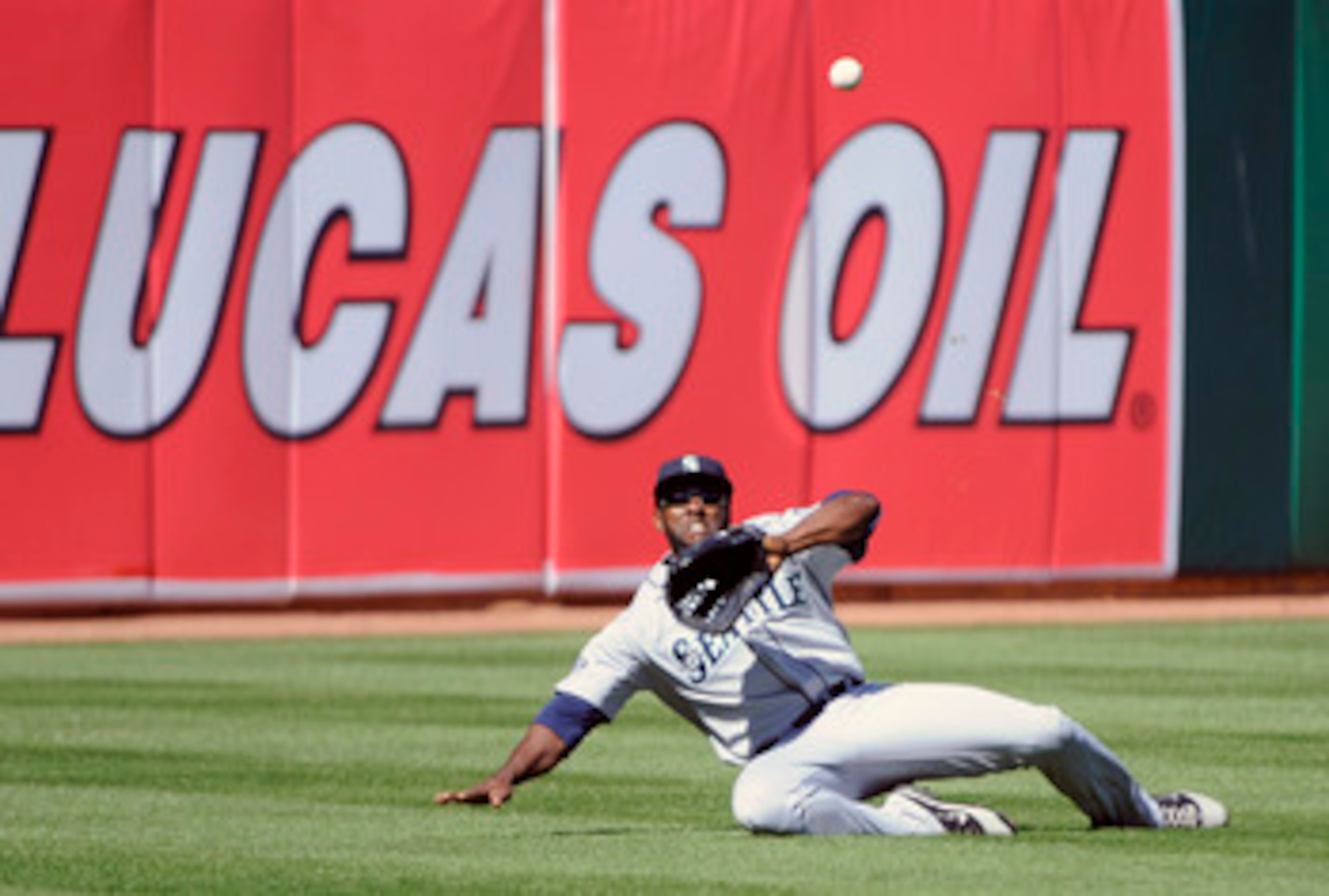 OAKLAND, CA - APRIL 3: Milton Bradley #15 of the Seattle Mariners makes a sliding catch in left-field against the Oakland Athletics during a MLB baseball game at the Oakland-Alameda County Coliseum April 3, 2011 in Oakland, California.  (Photo by Thearon