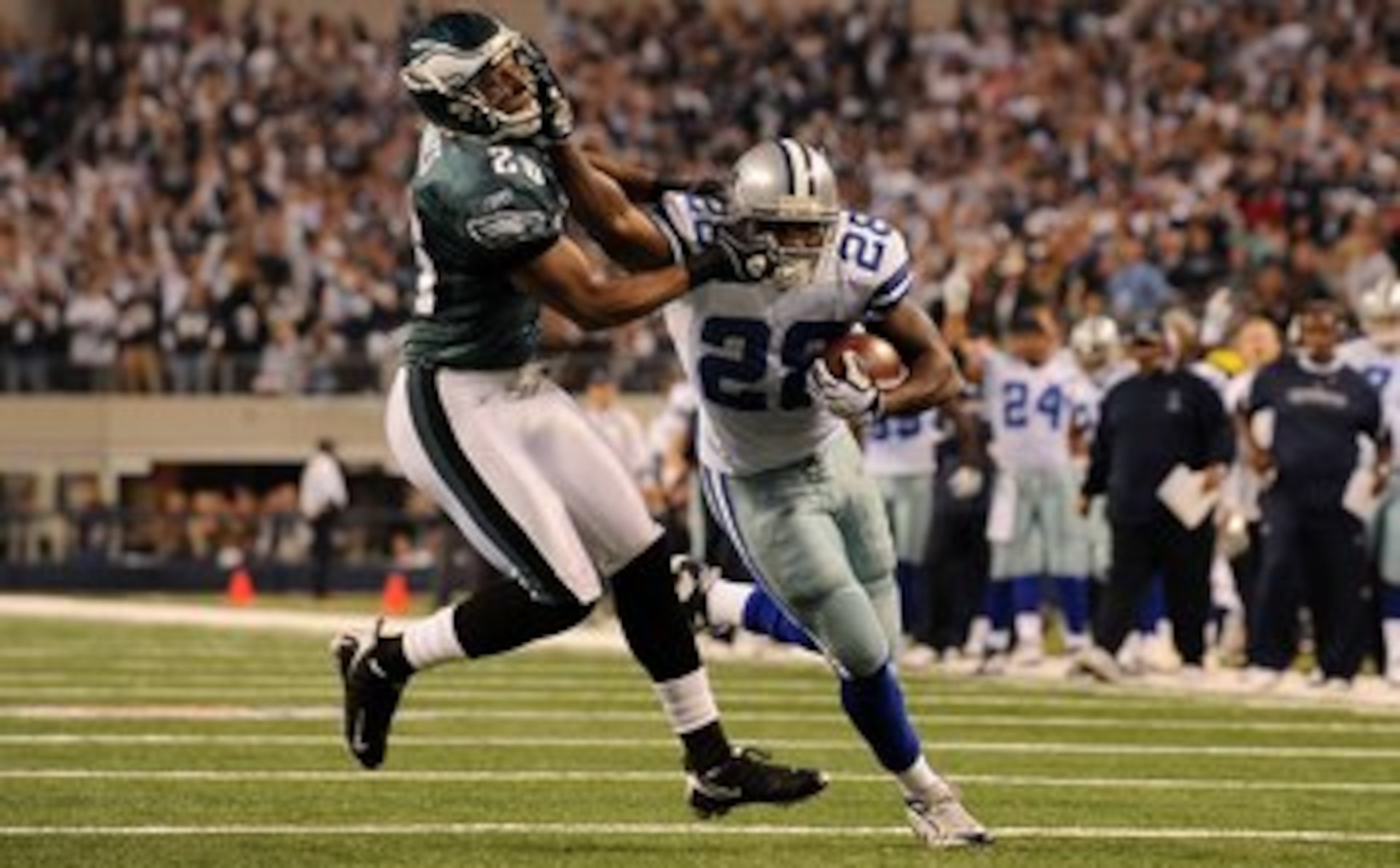 ARLINGTON, TX - JANUARY 09:  Running back Felix Jones #28 of the Dallas Cowboys runs the ball past Sean Jones #26 of the Philadelphia Eagles during the 2010 NFC wild-card playoff game at Cowboys Stadium on January 9, 2010 in Arlington, Texas.  (Photo by R