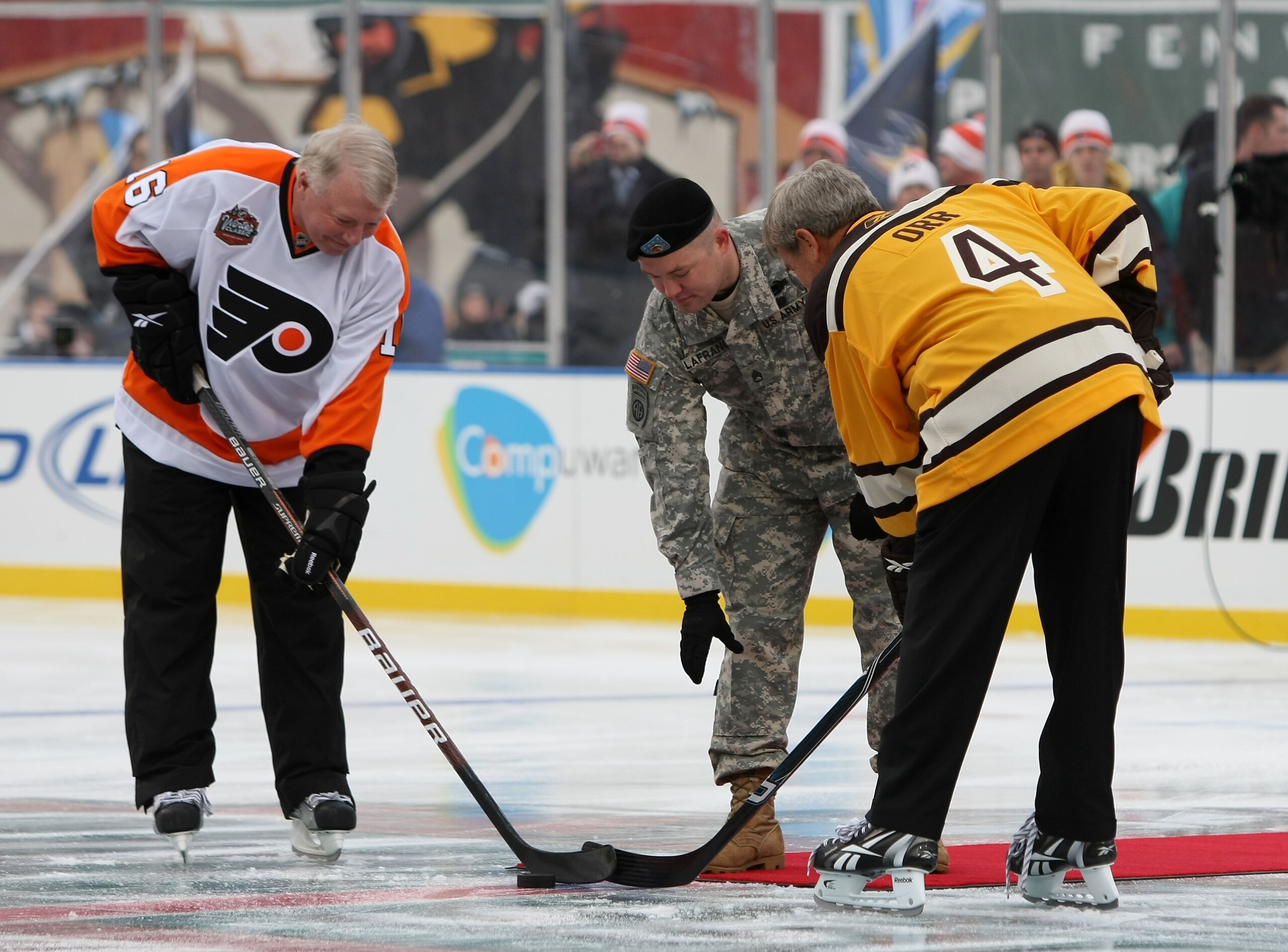 BOSTON - JANUARY 01: Staff Sergeant Ryan R. LaFrance (C) drops the ceremonial first puck for Bobby Clarke #16 (L) honorary captain of the Philadelphia Flyers and Bobby Orr #4 (R) honorary captain of the Boston Bruins during the 2010 Bridgestone Winter Cl BOSTON - JANUARY 01: Staff Sergeant Ryan R. LaFrance (C) drops the ceremonial first puck for Bobby Clarke #16 (L) honorary captain of the Philadelphia Flyers and Bobby Orr #4 (R) honorary captain of the Boston Bruins during the 2010 Bridgestone Winter Cl