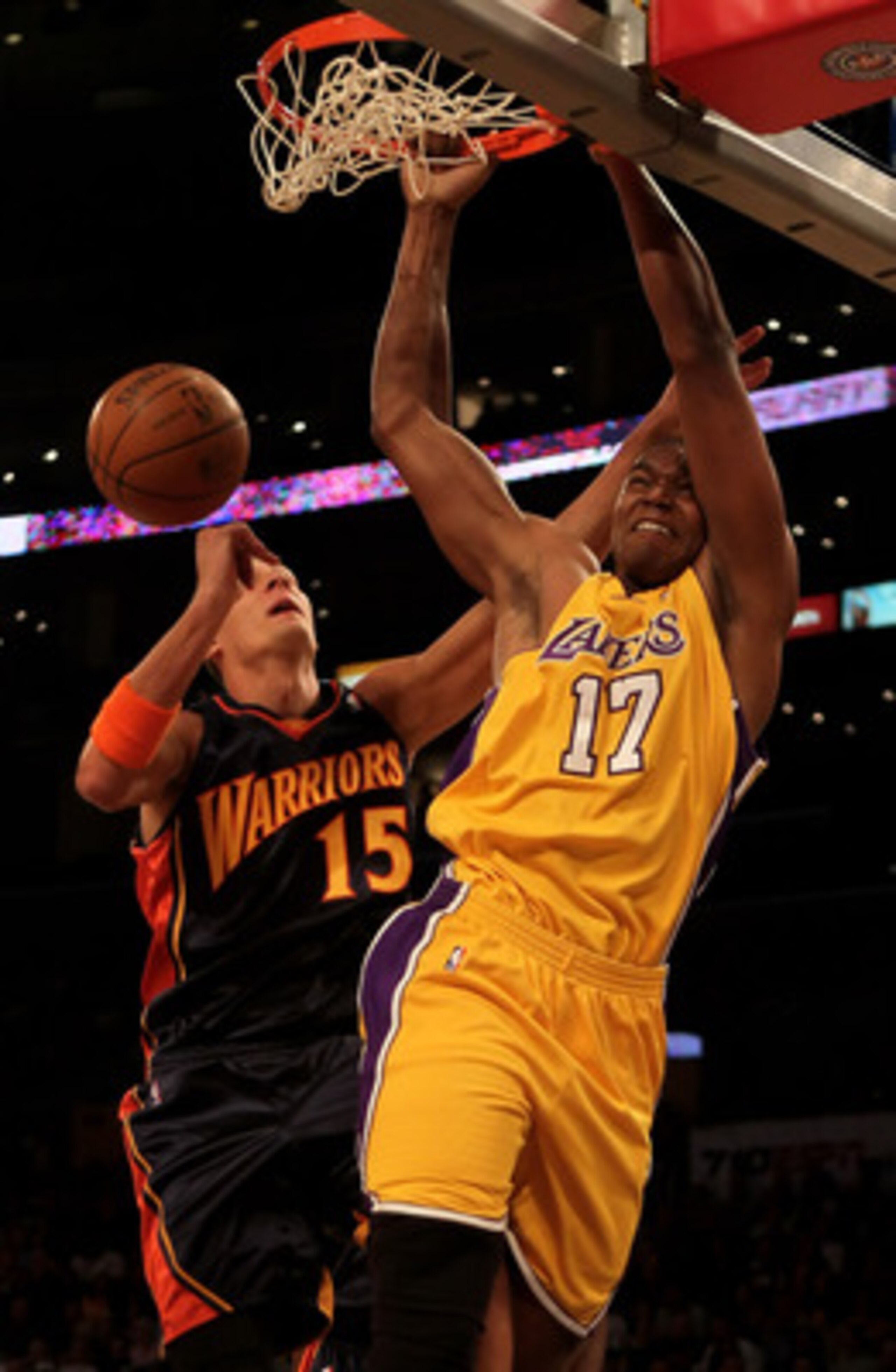 LOS ANGELES, CA - FEBRUARY 16:  Andrew Bynum #17 of the Los Angeles Lakers drives to the basket past Andris Biedrins #15 of the Golden State Warriors for a dunk in the first half at Staples Center on February 16, 2010 in Los Angeles, California. NOTE TO U